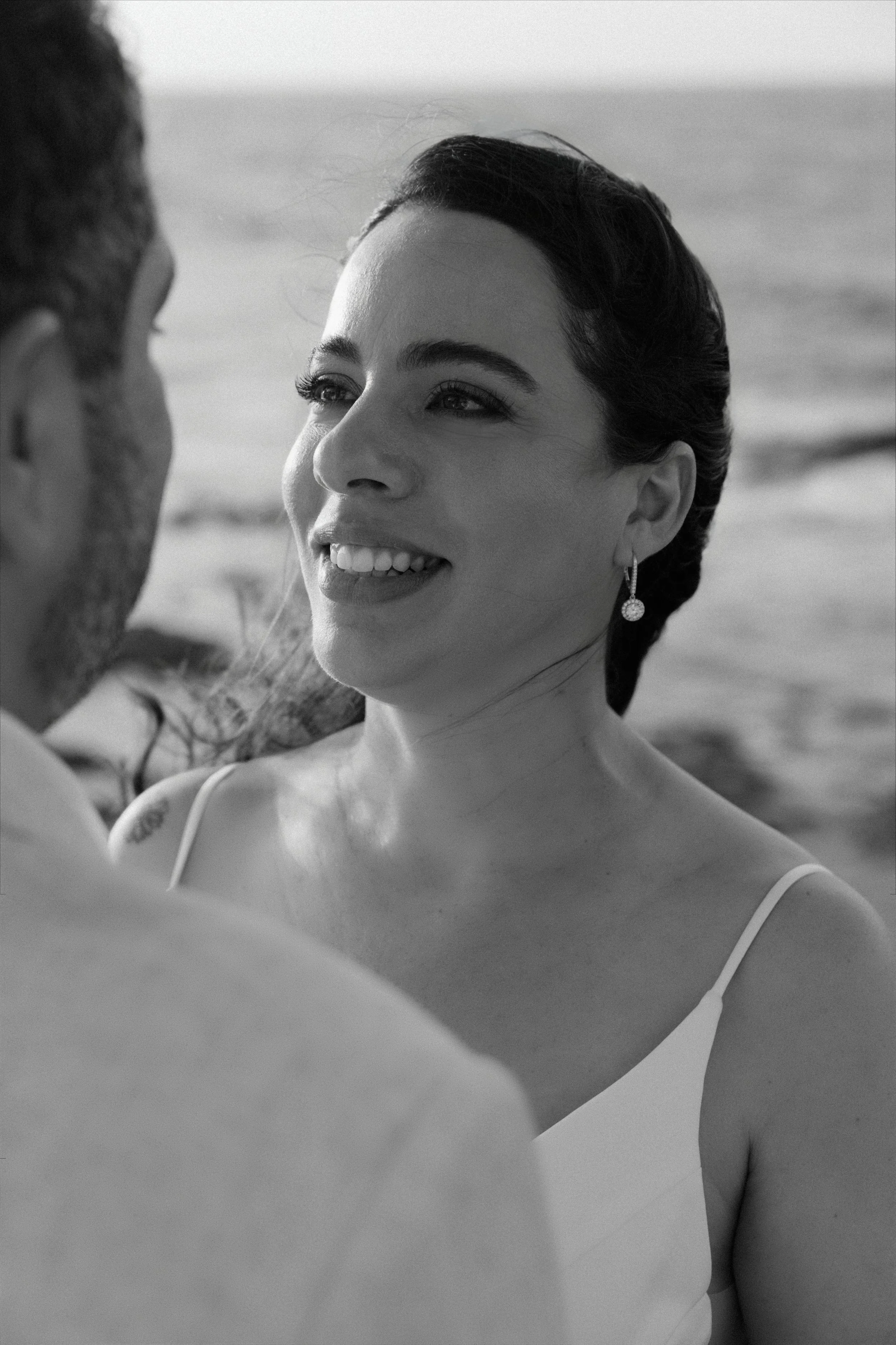 Couple holding hands beneath a white floral arch during their Puerto Rico beach elopement