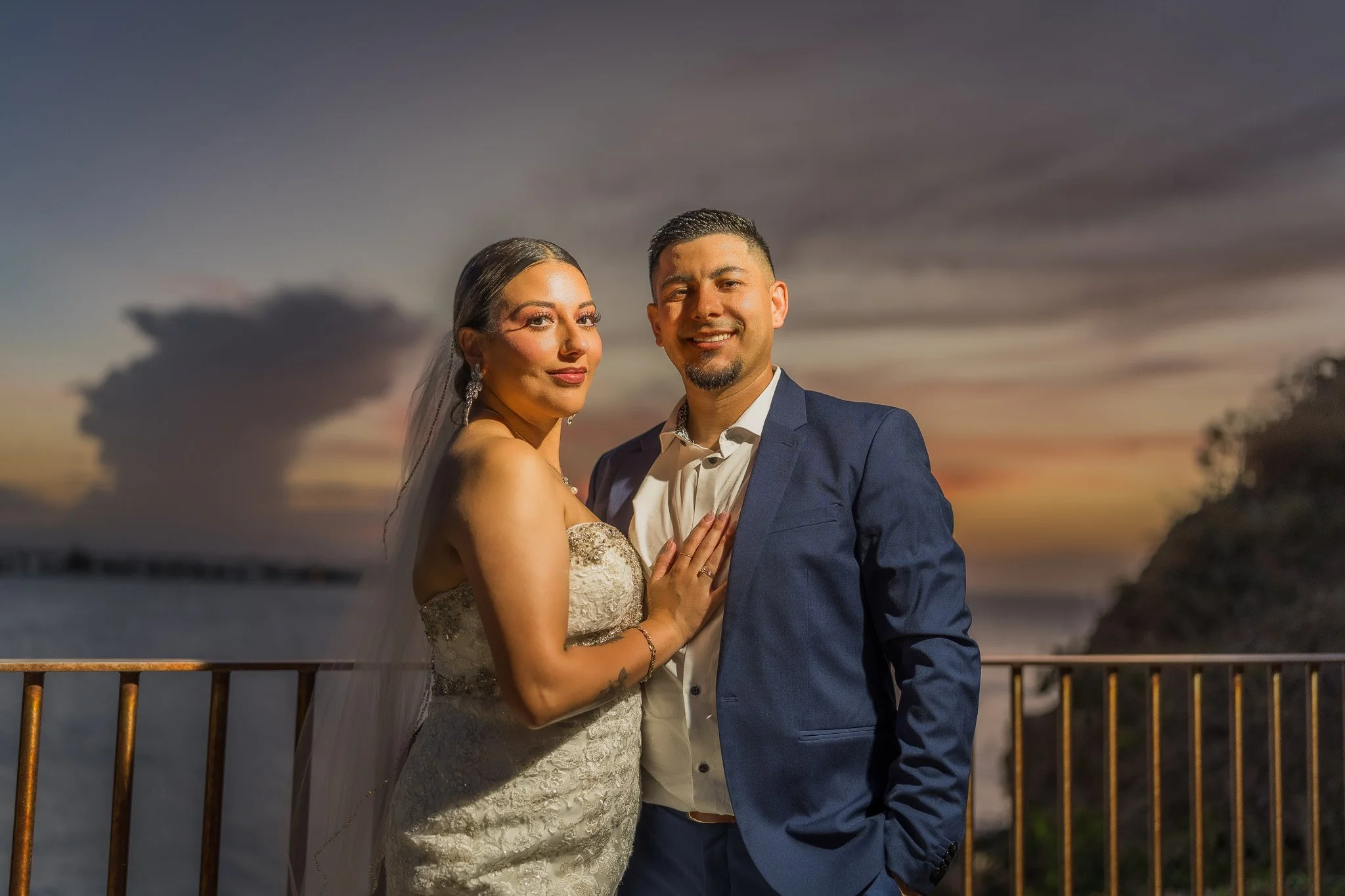 Bride and groom posing together at twilight overlooking the Caribbean Sea after their luxury destination elopement in Old San Juan, Puerto Rico.