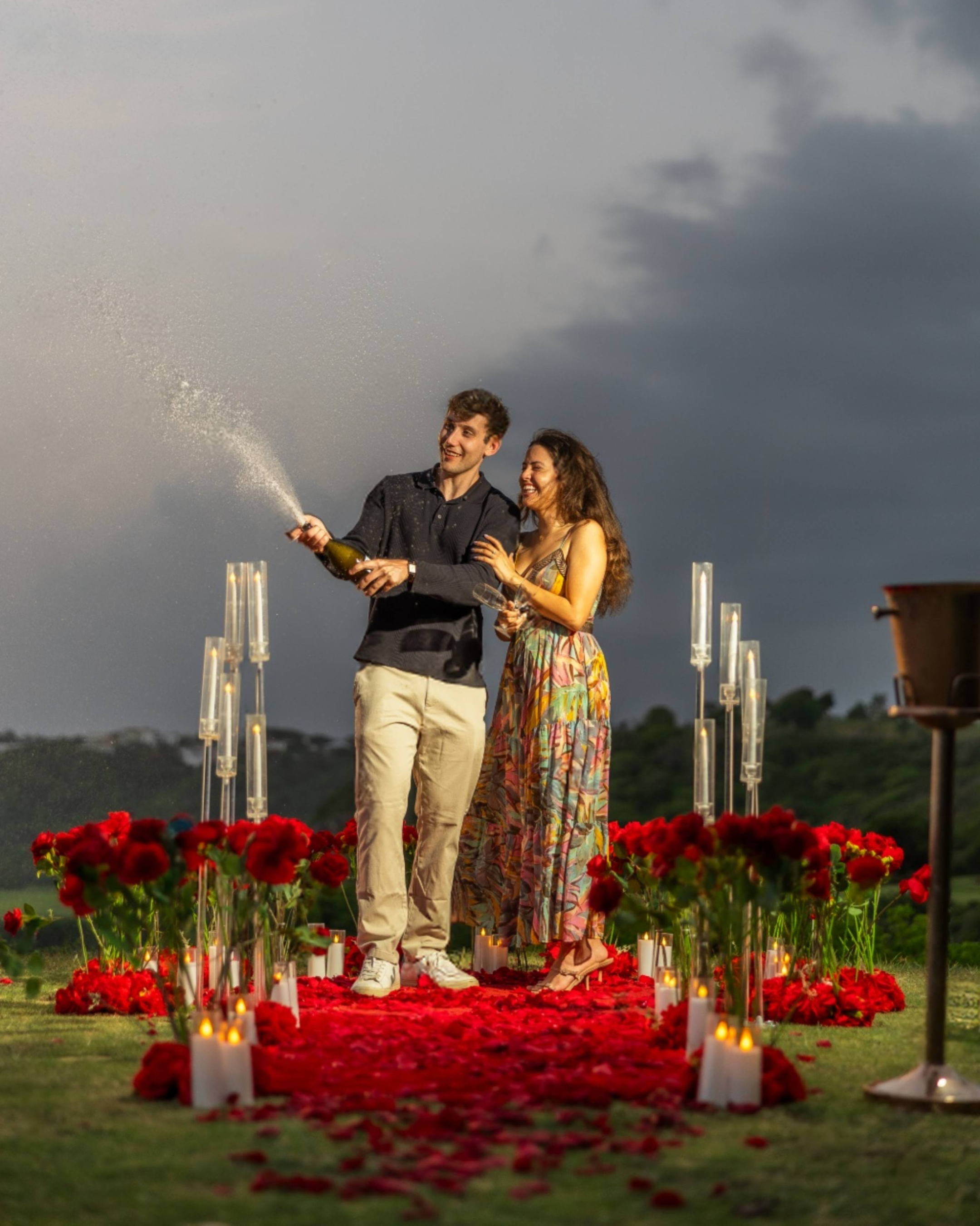 Newly engaged couple celebrating their engagement with champagne at Royal Isabela overlooking Puerto Rico's coastline.
