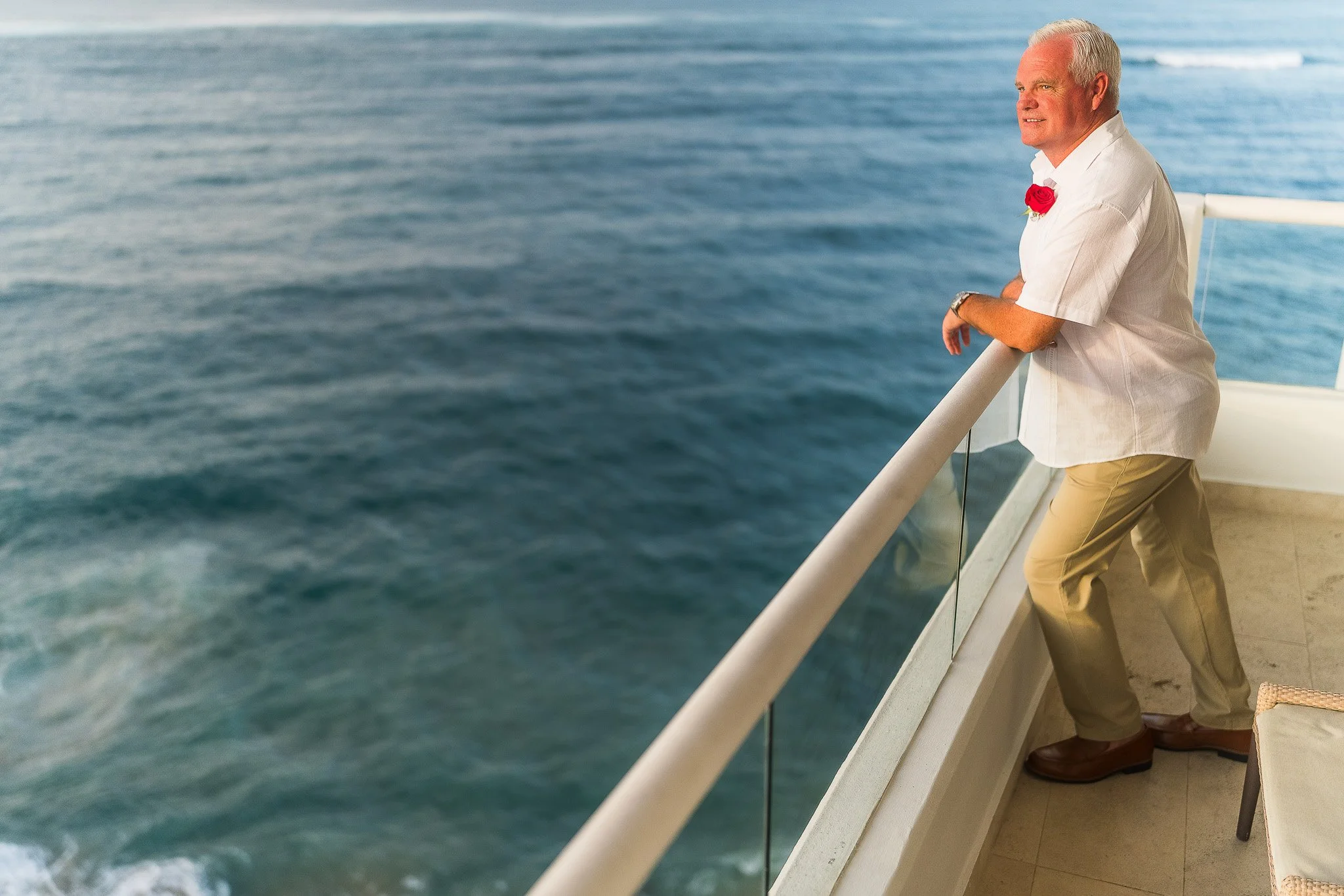 Groom overlooking the beach from the Condado Vanderbilt Hotel balcony during his Puerto Rico elopement wedding
