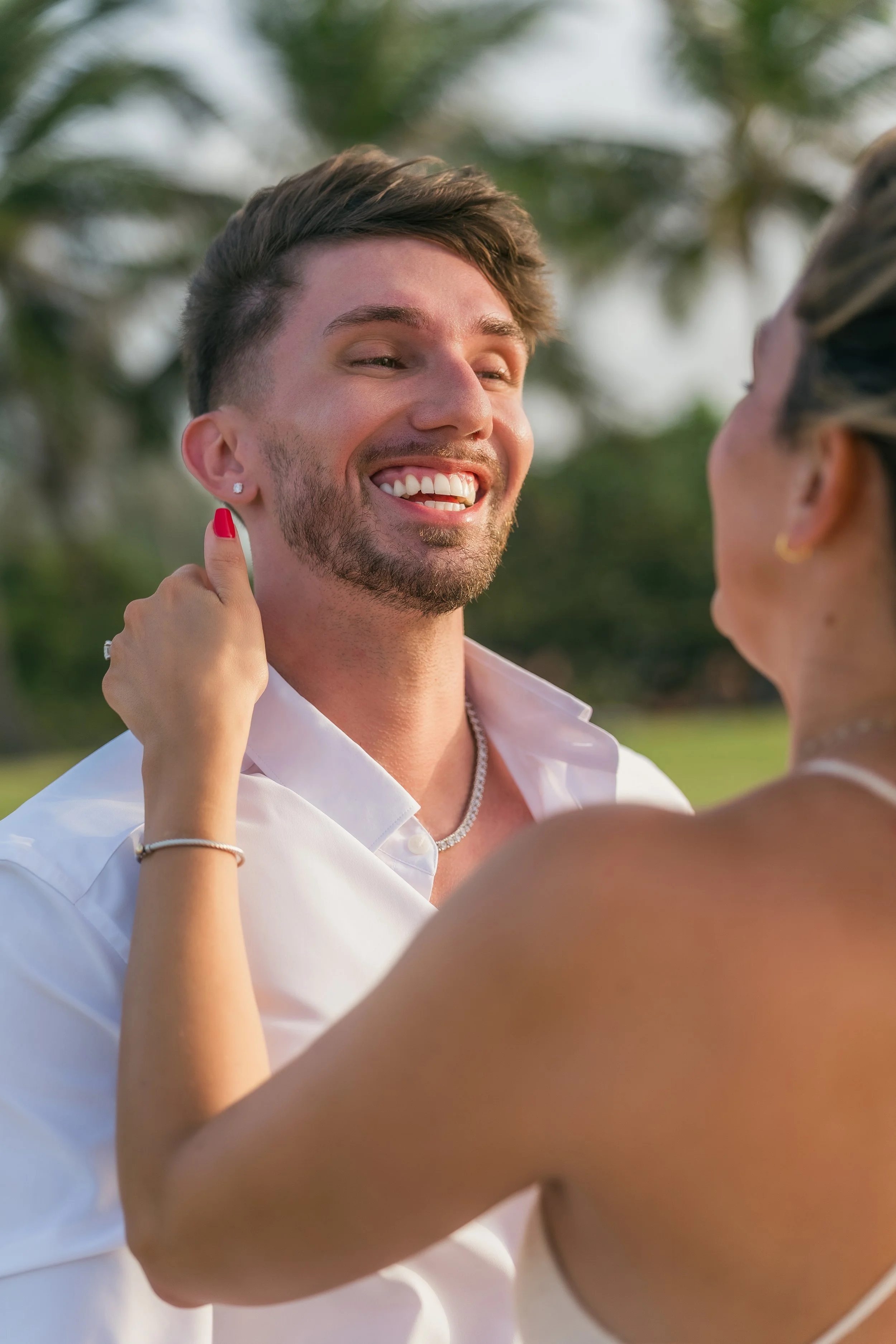 Man smiling during her engagement session in Puerto Rico taken by a marriage proposal photographer at Escambrón Beach