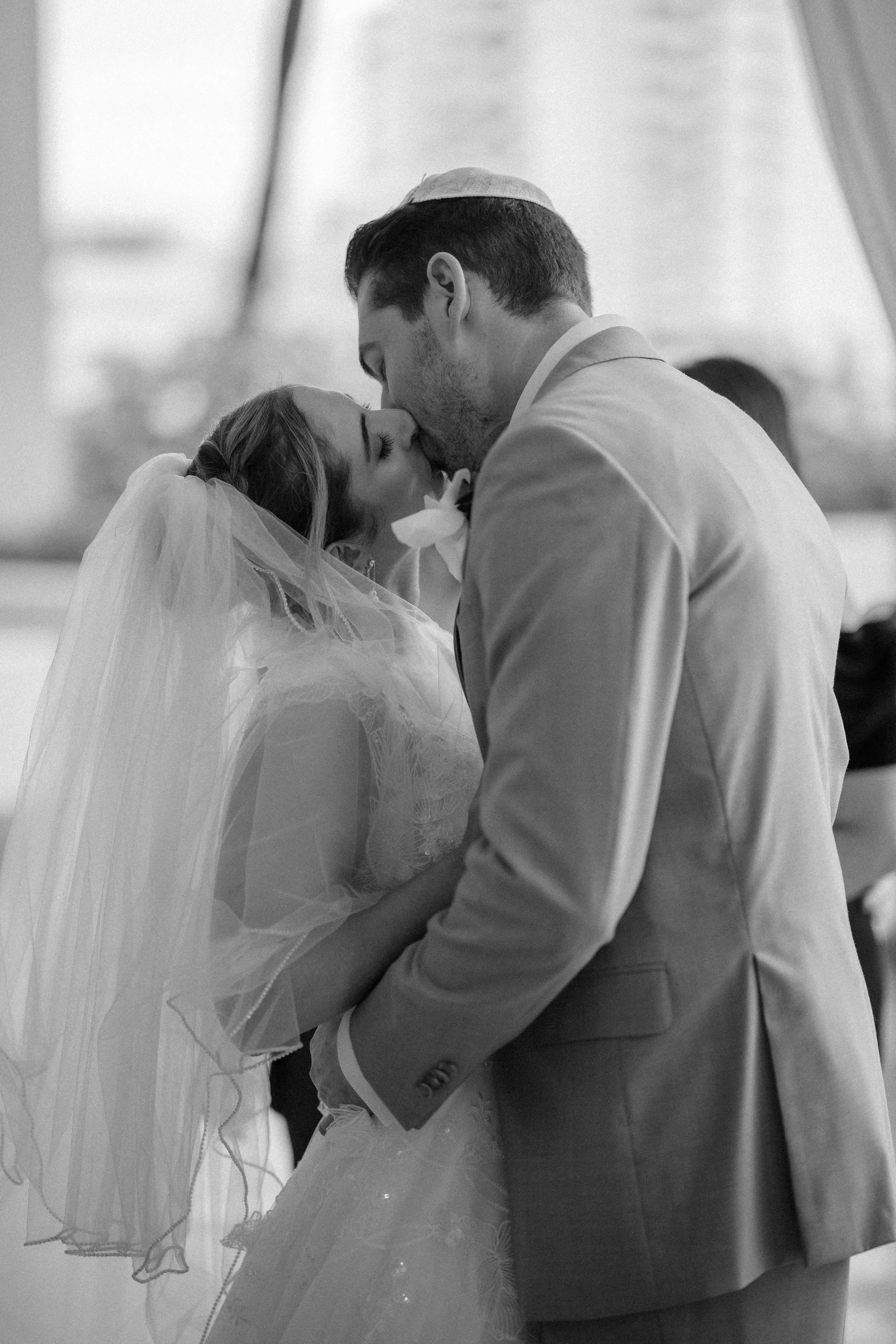 First kiss during a Jewish wedding ceremony shot by a luxury elopement photographer in Puerto Rico at La Concha Resort
