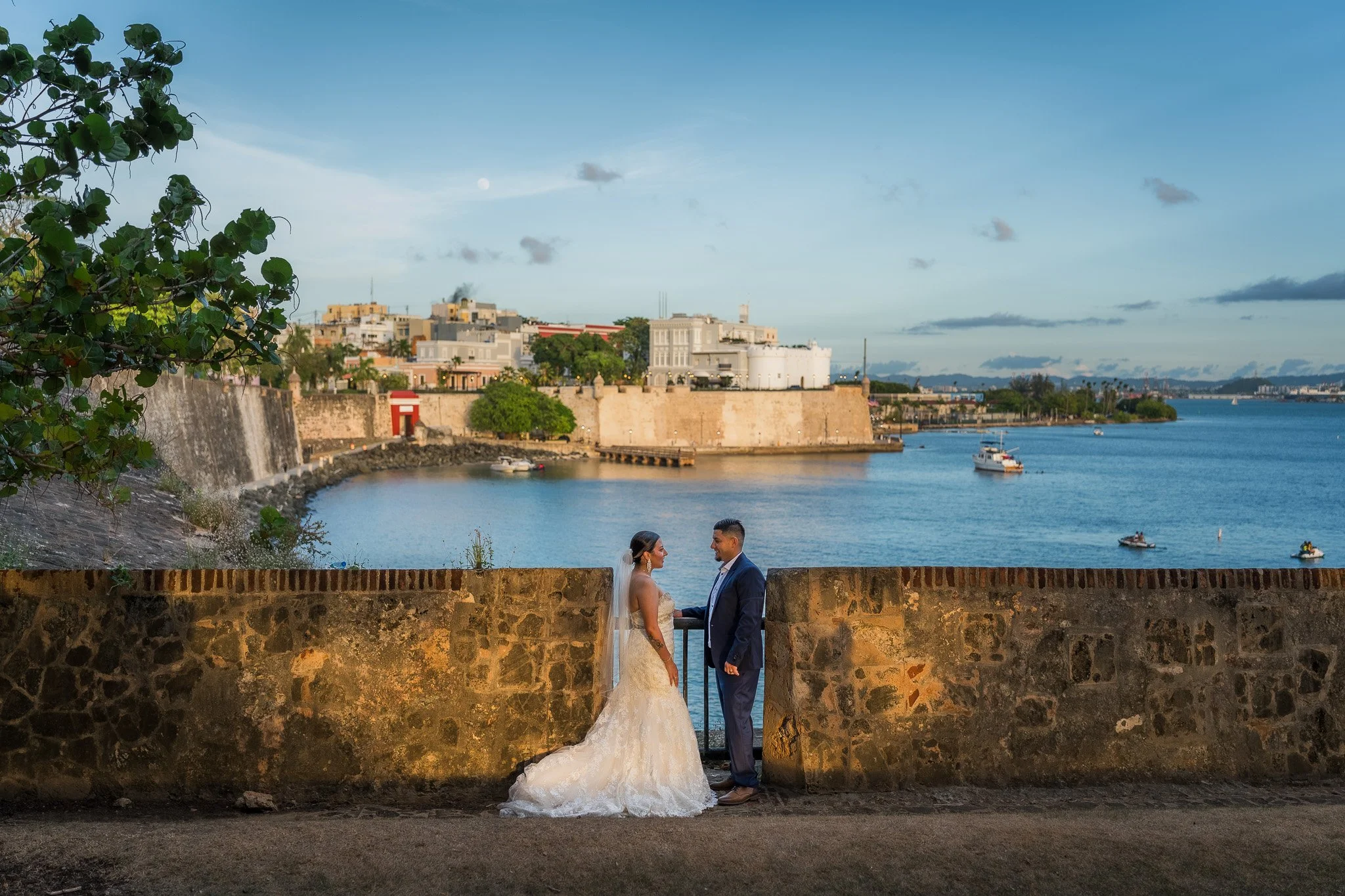 Bride and groom overlooking San Juan Bay from the historic city walls during a luxury destination elopement in Old San Juan, Puerto Rico.