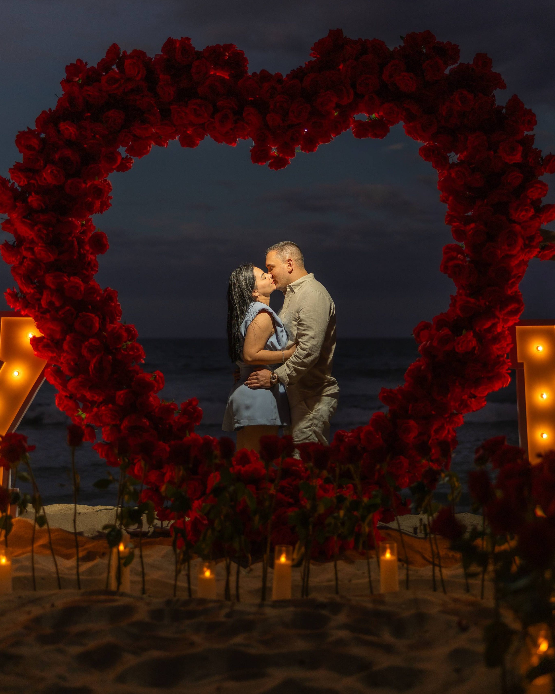 Destination marriage proposal in Puerto Rico with candles, roses, and ocean backdrop.