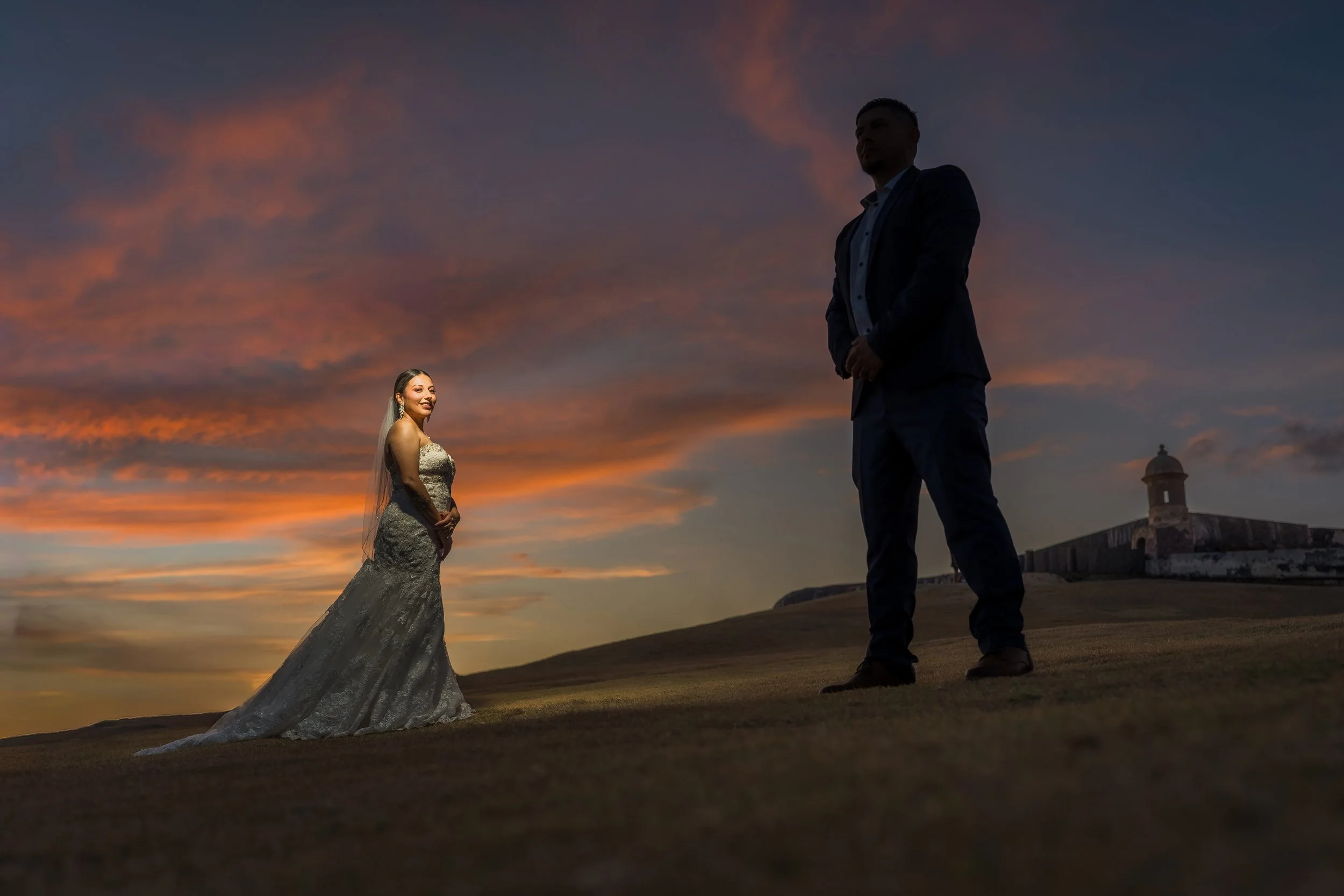 Bride and groom posing together at twilight overlooking the Caribbean Sea after their luxury destination elopement in Old San Juan, Puerto Rico.