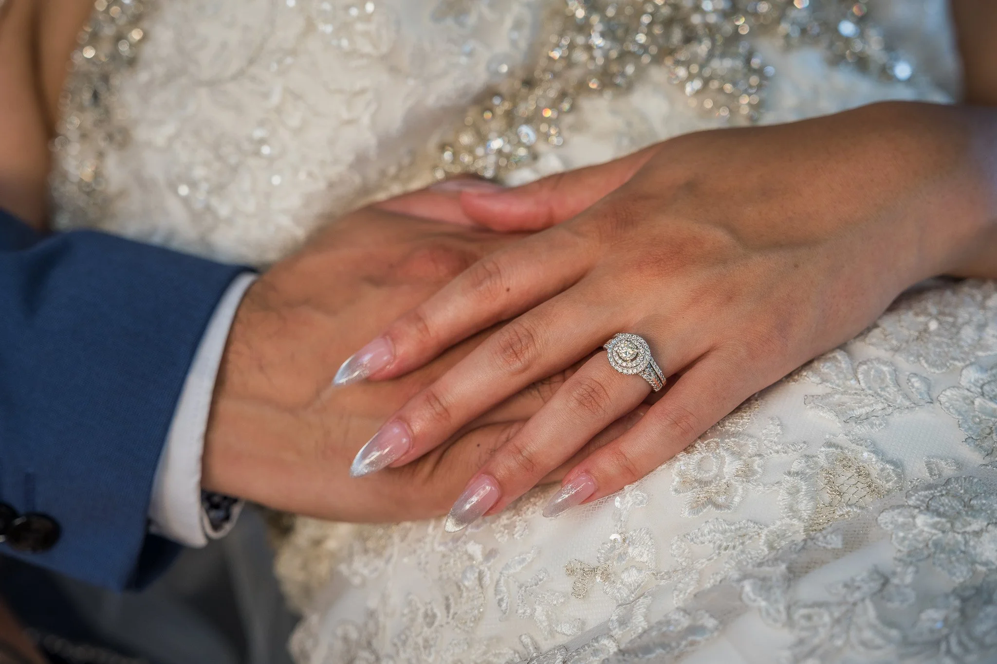 Close-up of the bride's diamond engagement ring and wedding band resting on the groom's hand during a luxury Puerto Rico destination elopement.