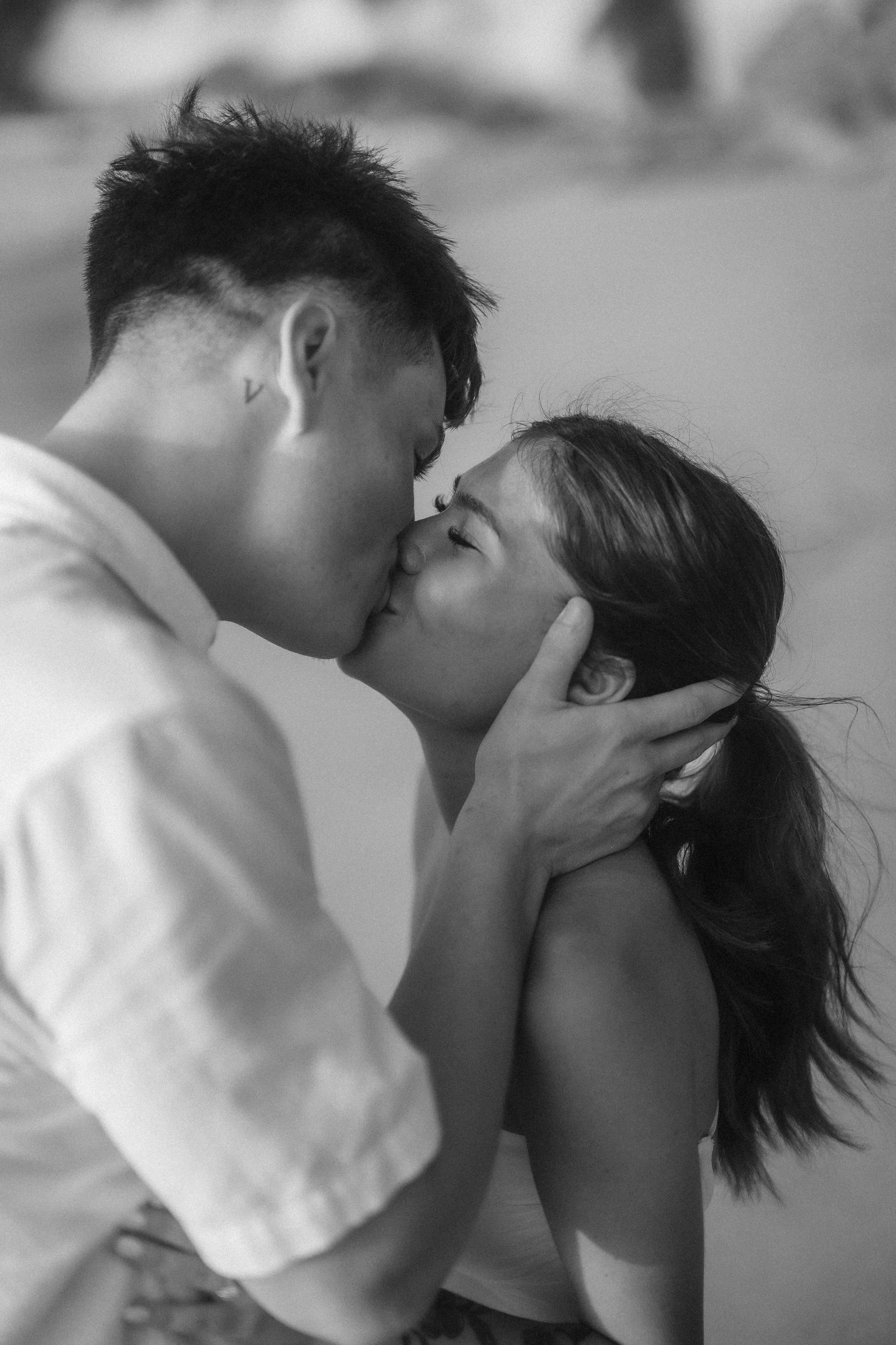 Newly engaged couple kissing at Punta Borinquen Beach in Aguadilla, Puerto Rico taken by an elopement photographer