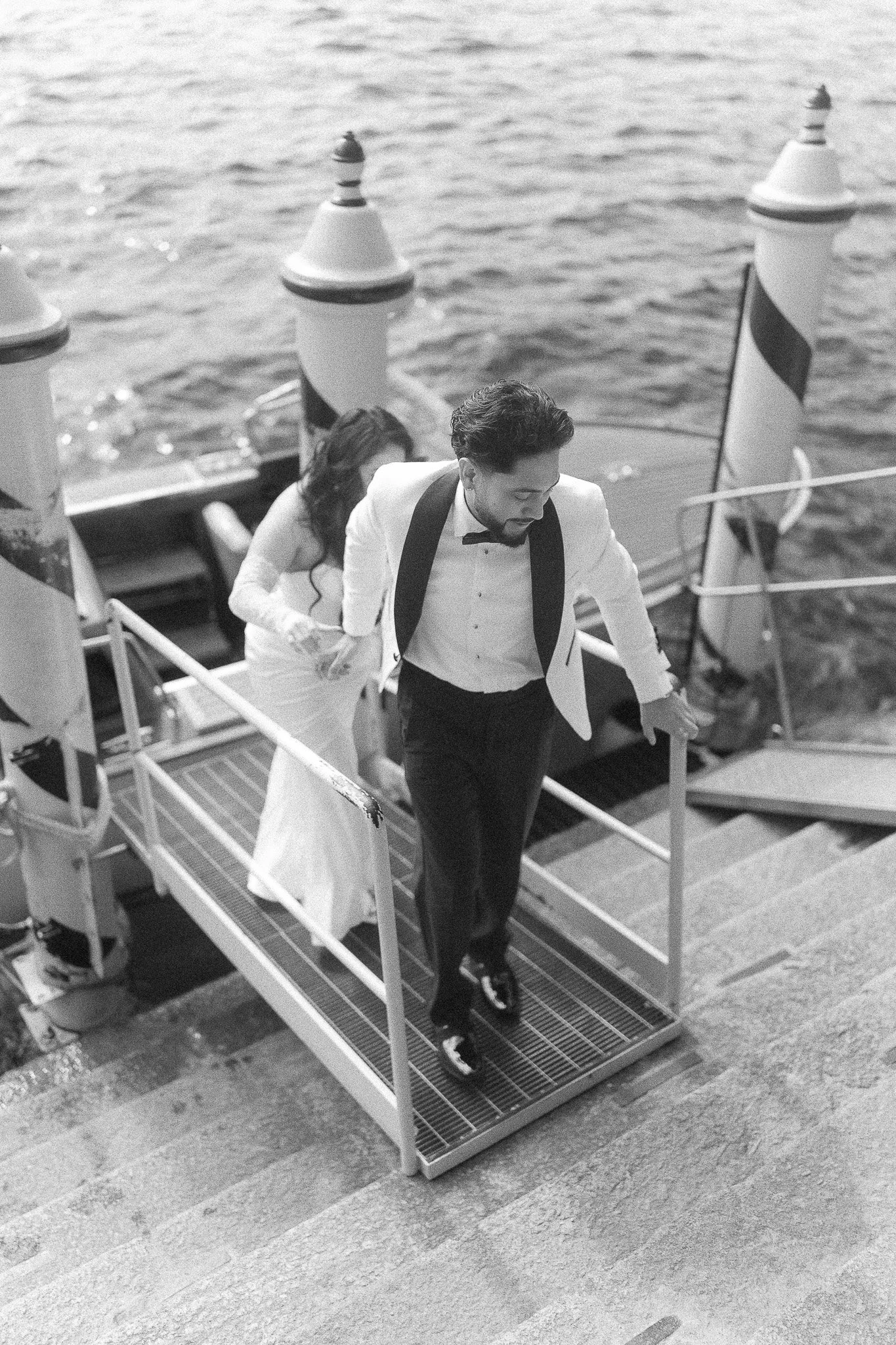 Bride and groom getting off boat at Lake Como for their editorial wedding at Villa del Balbianello taken by a luxury wedding photographer in Puerto Rico
