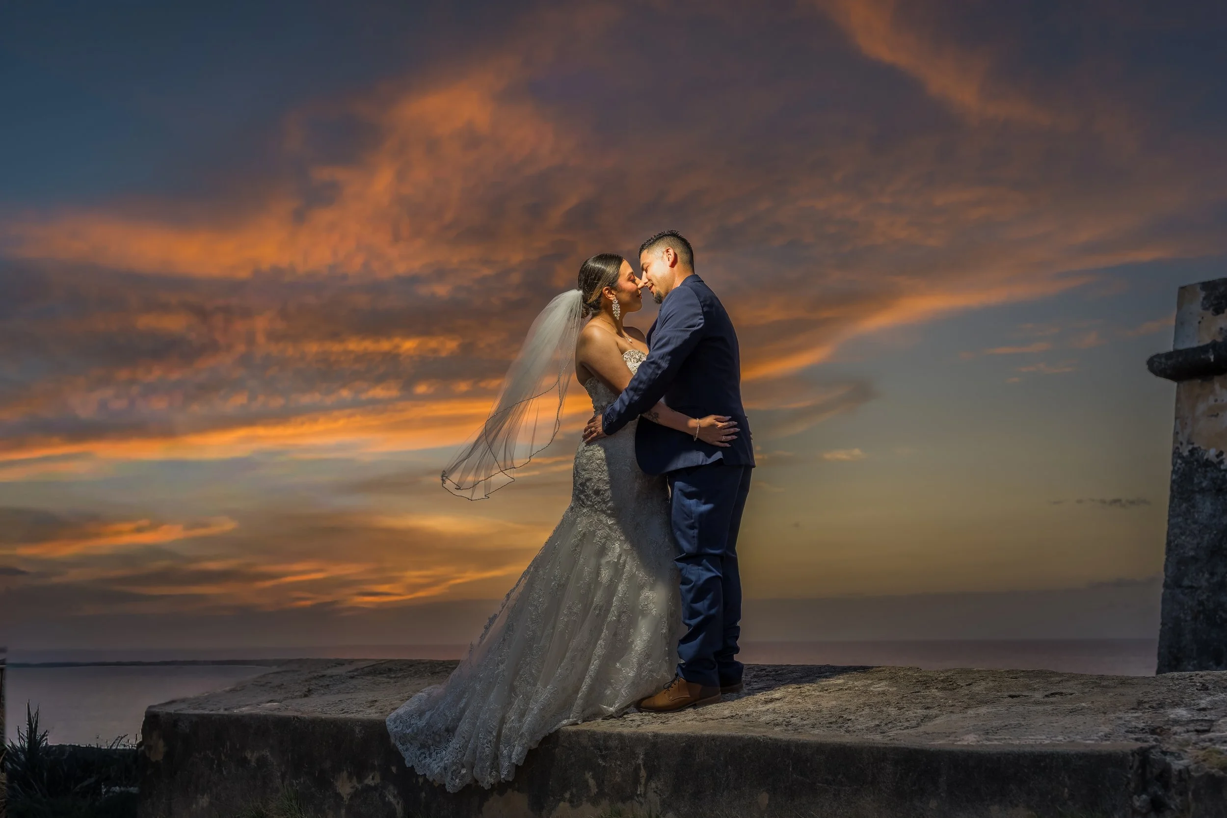 Bride and groom posing together at twilight overlooking the Caribbean Sea after their luxury destination elopement in Old San Juan, Puerto Rico.