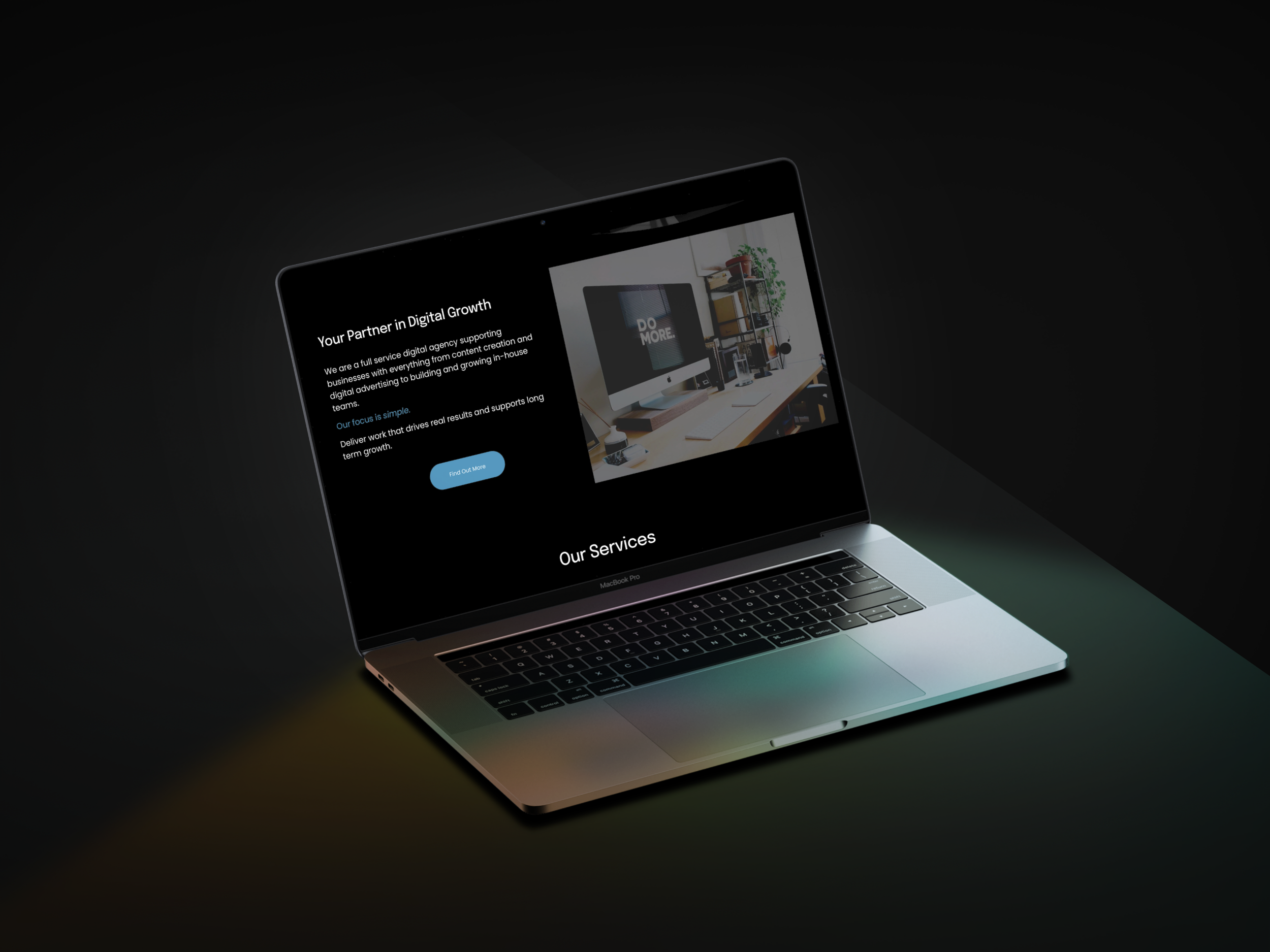 A laptop placed on a round wooden table displaying a webpage for Tailored Creative, a digital media agency. 