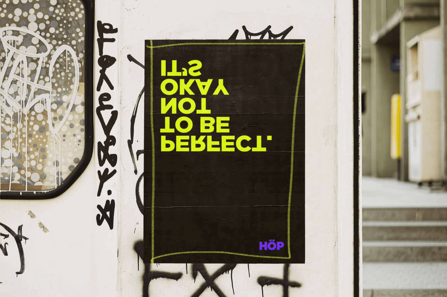 Cartel de HAGAMOS OTRO PLAN, en un muro rodeado de graffiti en un entorno urbano