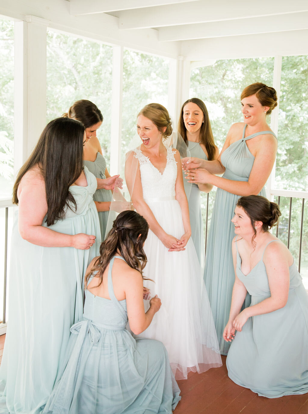 bride getting ready with bridesmaids assisting