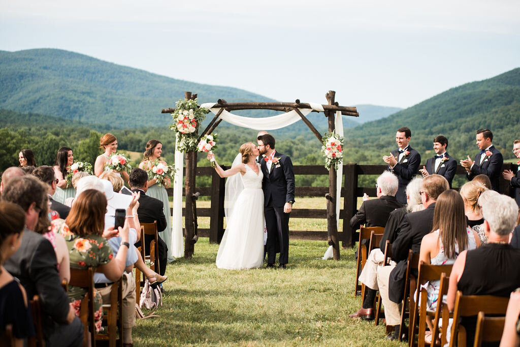 wedding ceremony celebrations, bride holds bouquet up in air