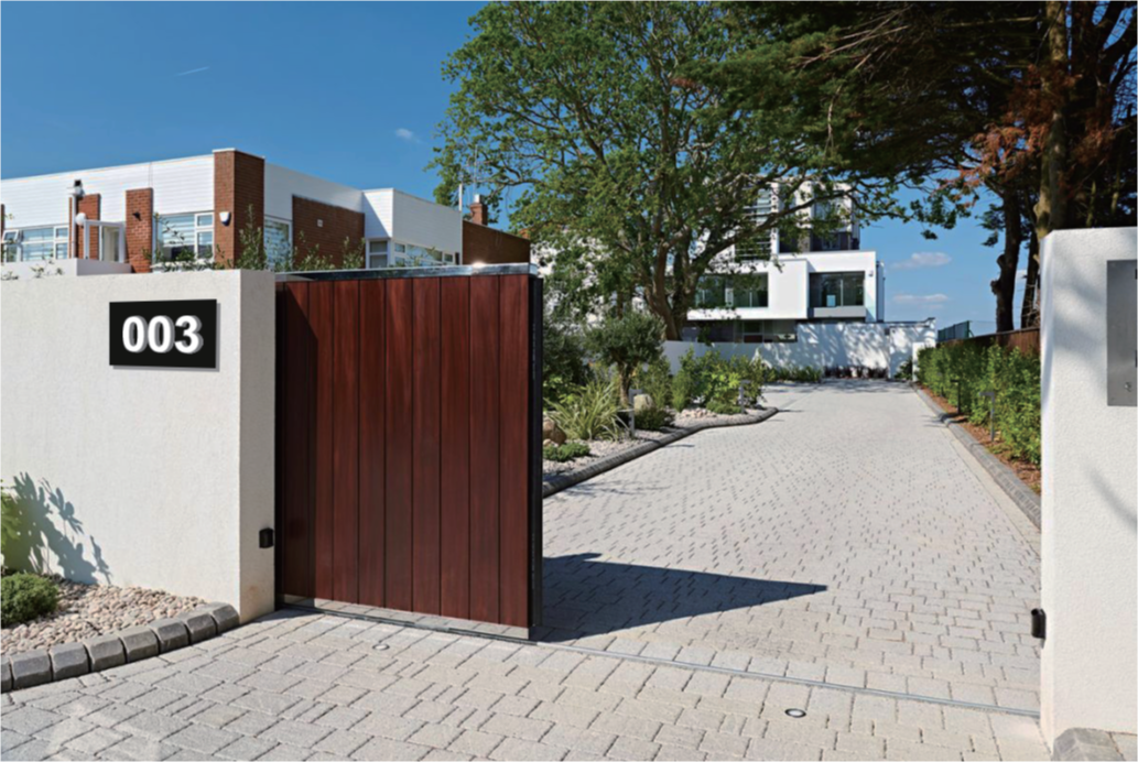 LED illuminated house numbers installed onto a mounting plaque on a fence