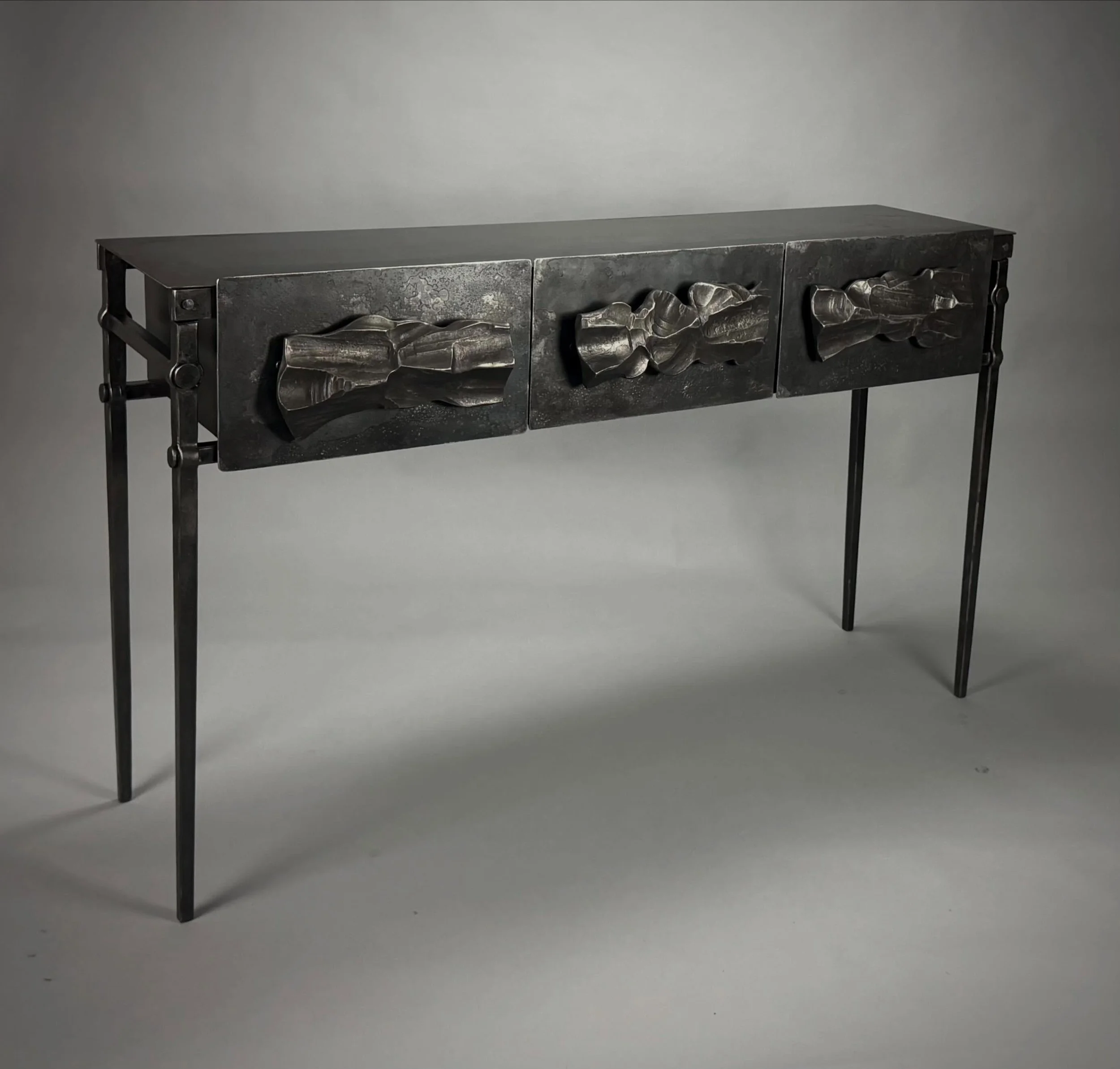 A new three drawer counsel table. This piece has all mortise and tenon joints the drawer fronts are riveted together. The drawer pulls are forged from 2&rdquo; round stock, making three different sculptures on the front. I will have this with me this
