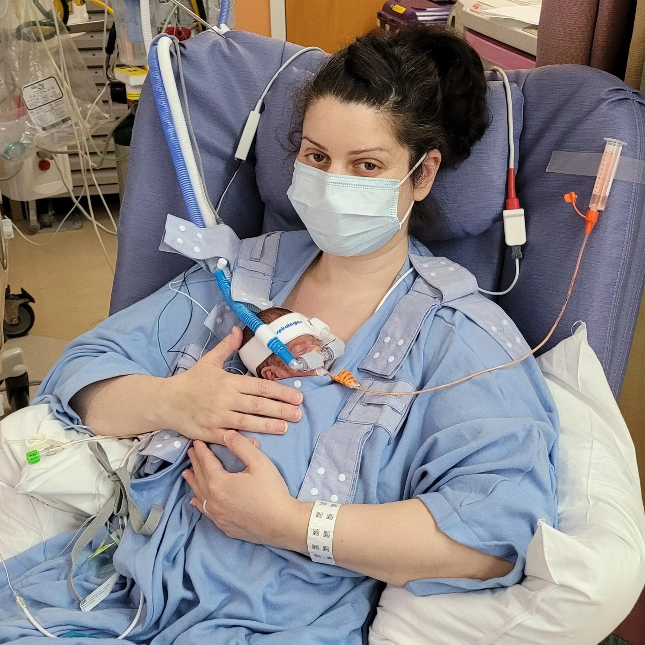 Mother holding her preterm baby in the NICU