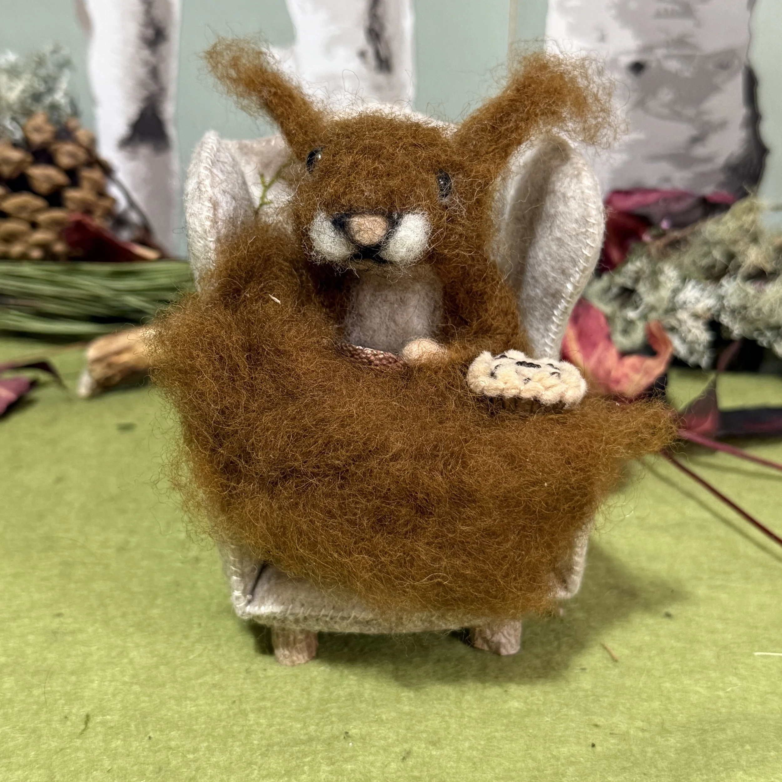 Squirrel in armchair with blackberry pie and copper cup