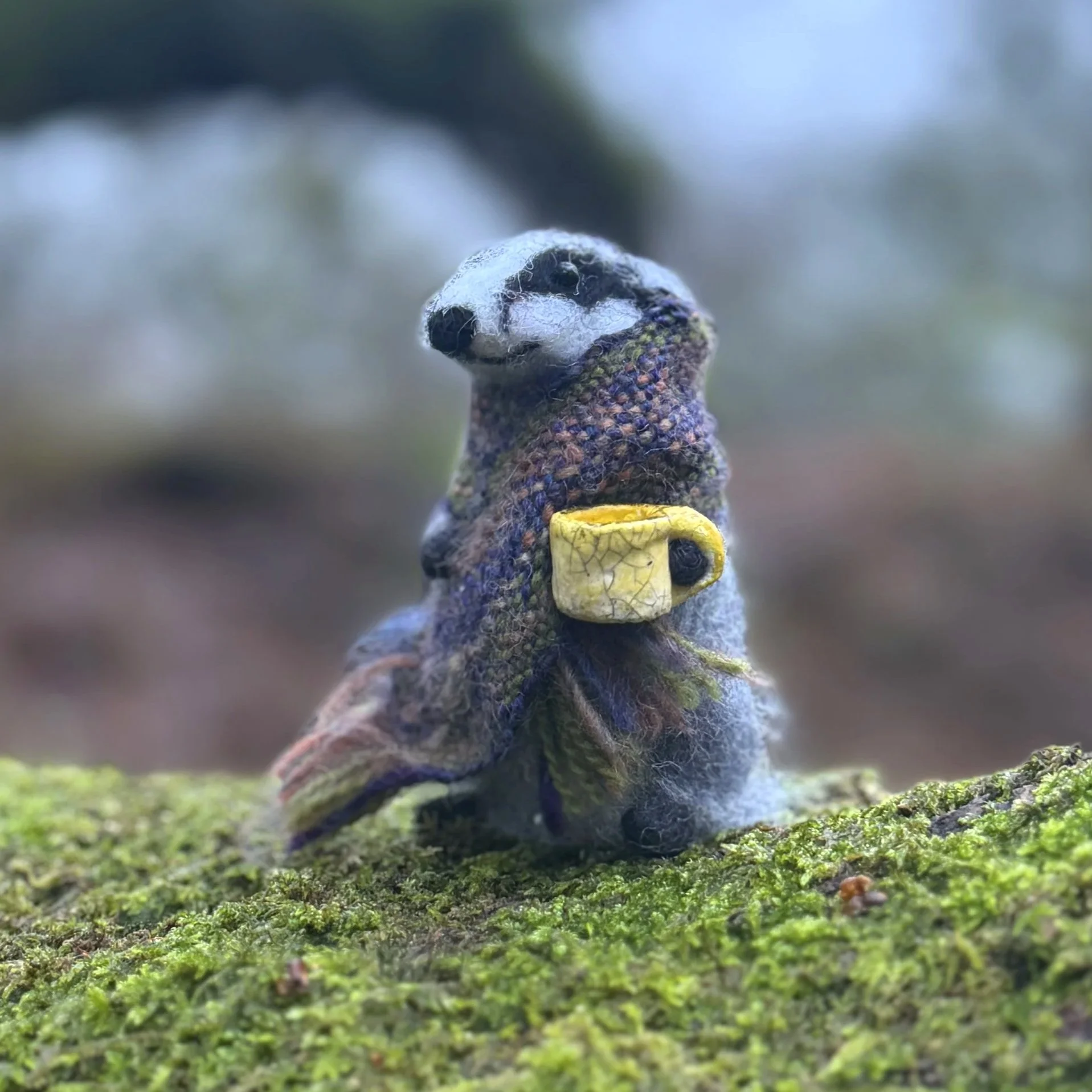 Badger with a handwoven wool scarf shawl and a yellow hand thrown little ceramic mug. Needle felted approx 9cm tall  £135