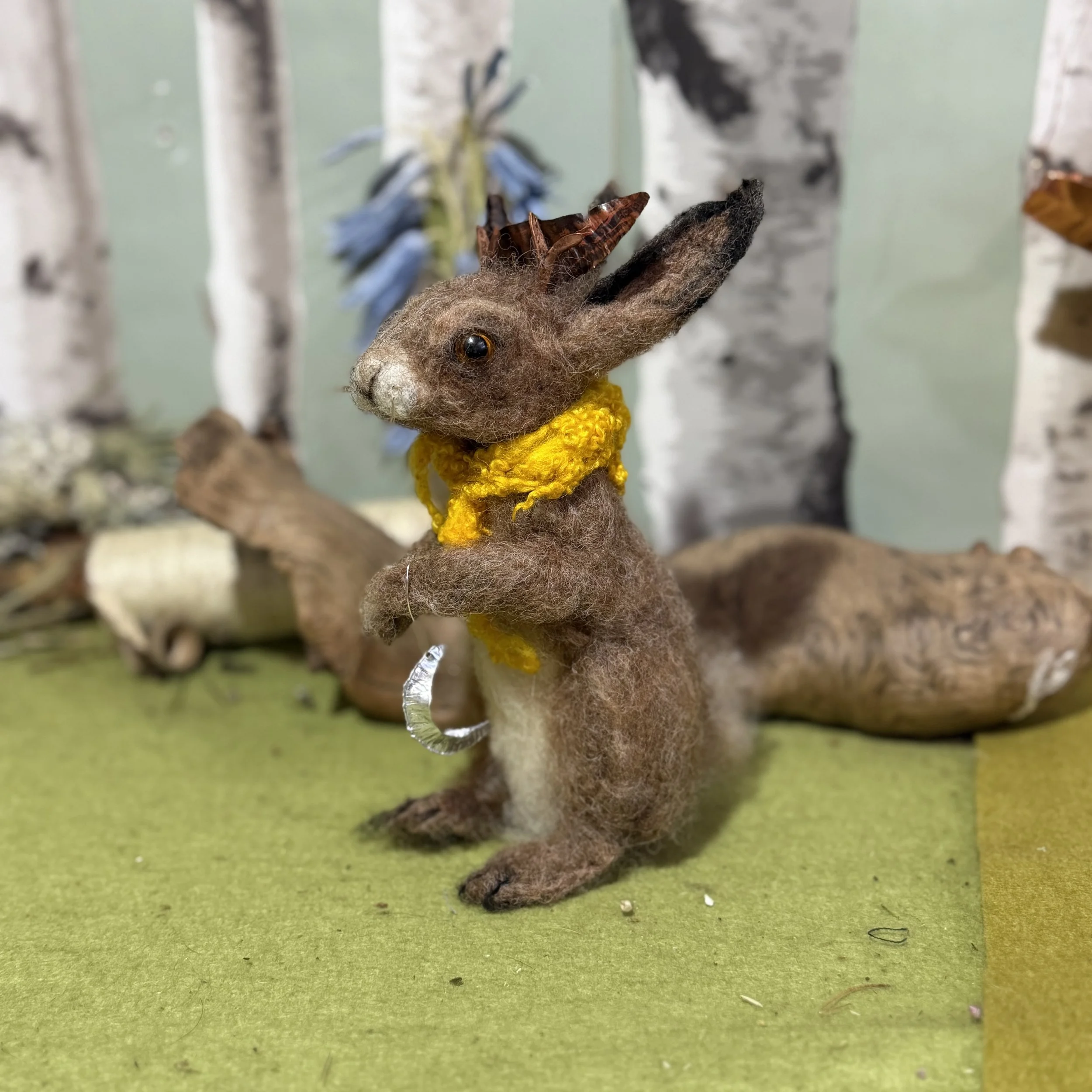 Hare with the Moon conjured a new moon Needle felted hare with copper antlers, copper moon headdress and wool scarf. They hold a metal hammered new moon. Hare is approx 16cm high £162