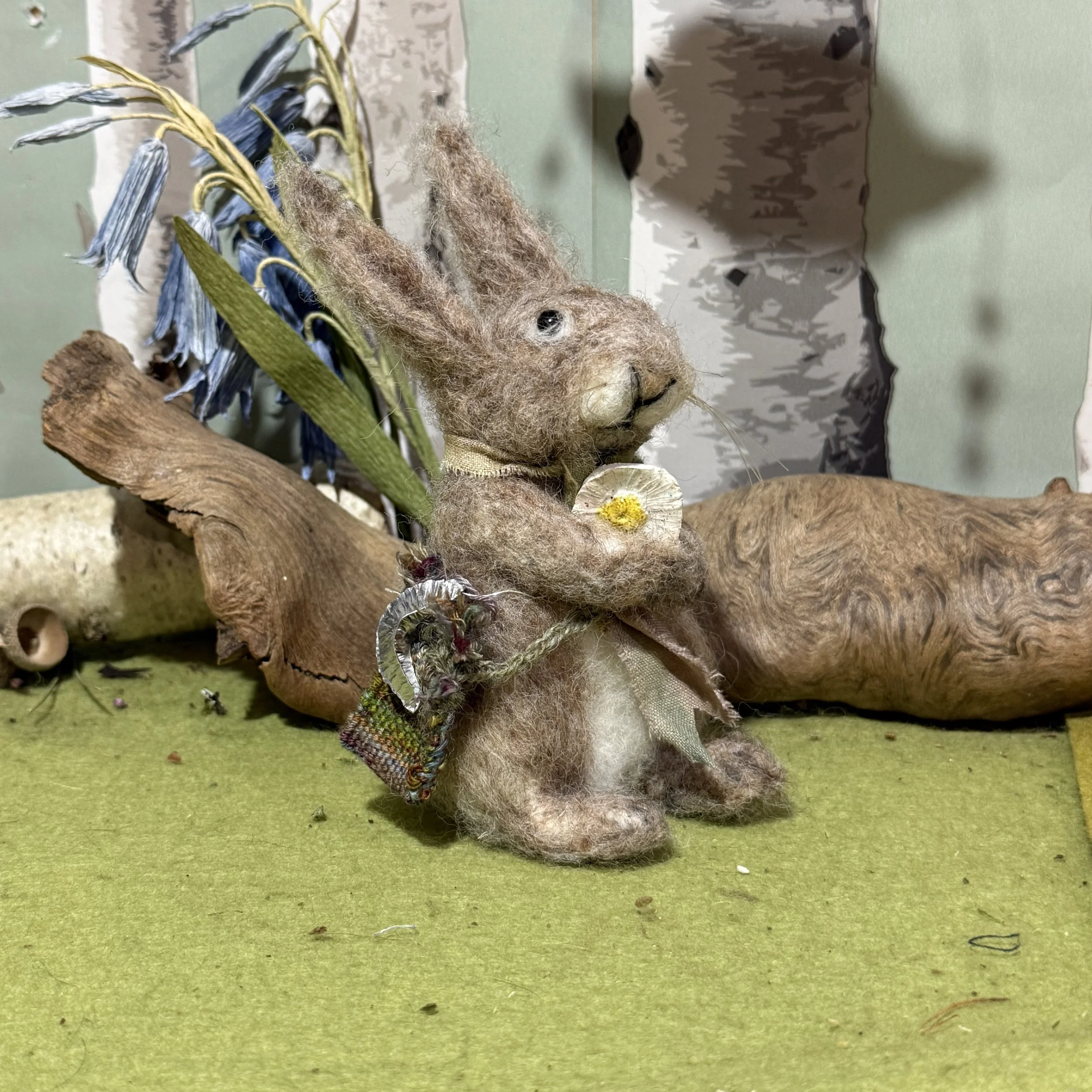 Needle felted Wish Gatherer rabbit. They carry a ceramic glazed cast of a daisy flower, a metal hammered moon,  a woven bag and plant dyed scarf. Inspired from the rabbit in The Gift Gatherers. They stand approx 11cm to top of head, 16cm to tips of e