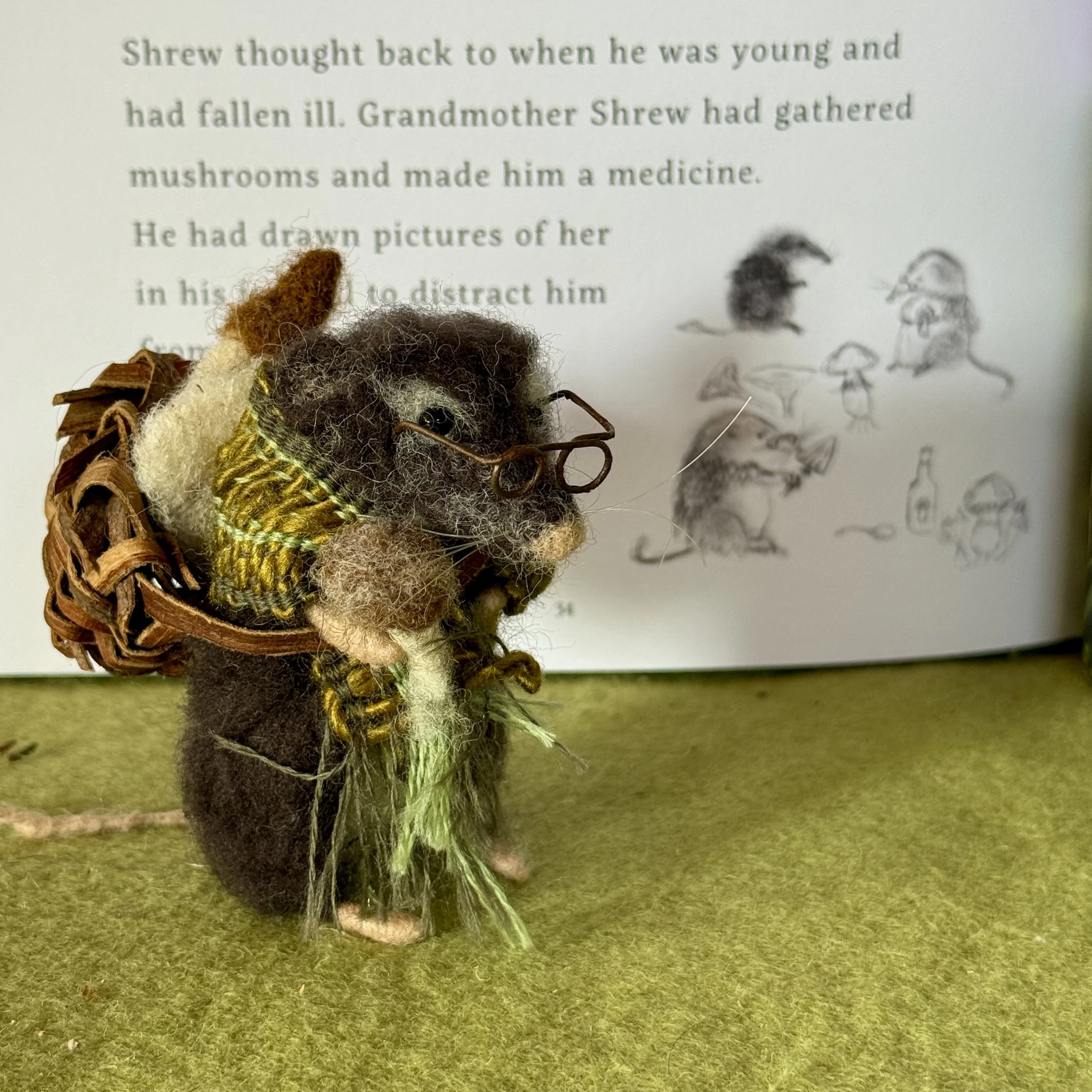 Grandmother shrew from the Gift Gatherers illustration. Felted old shrew with a woven shawl, willow bark basket and felted mushrooms gathered. approx 9cm tall.
