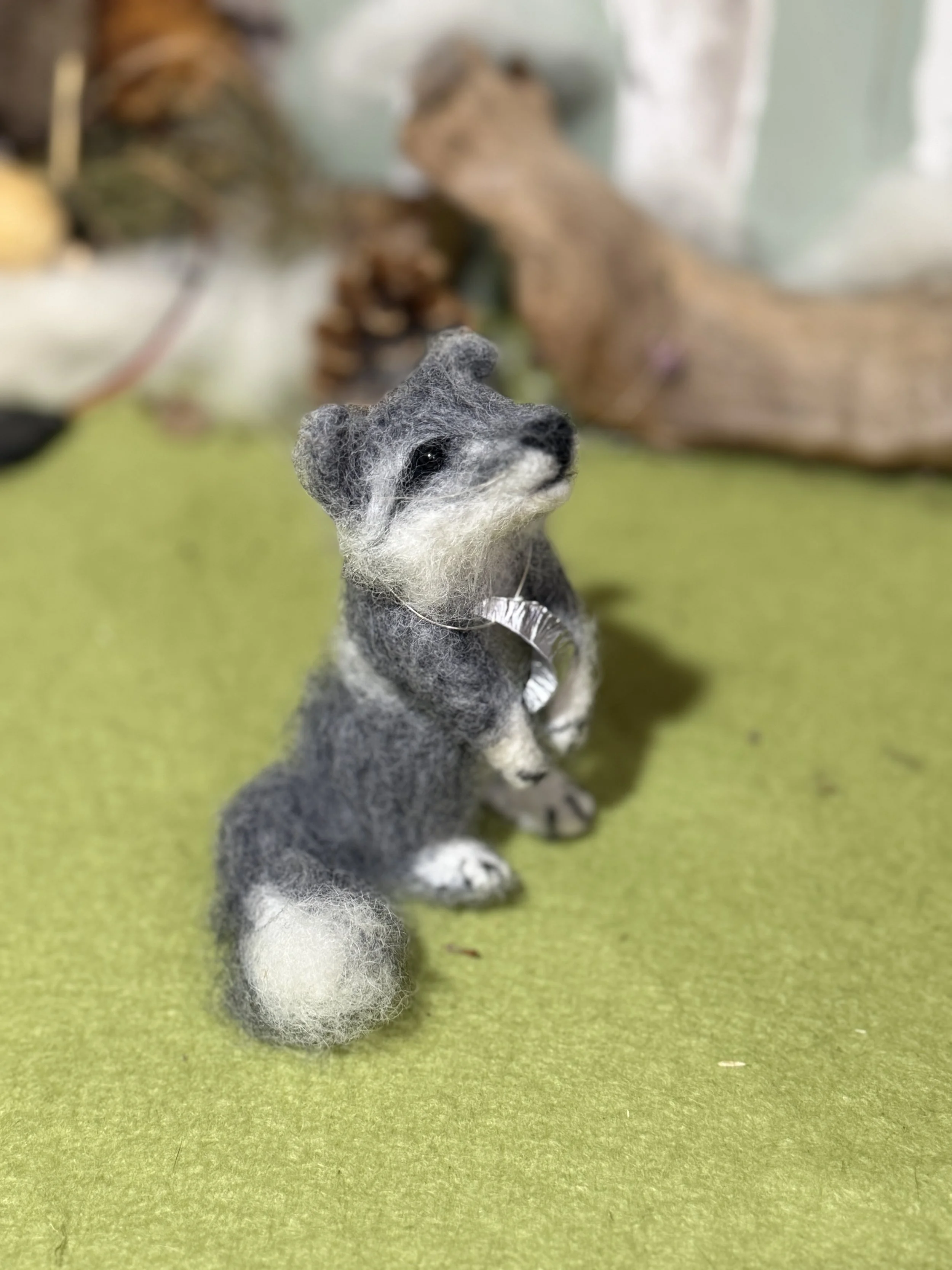 Baby Wolf Cub howling at the moon.  
Wolf cub 2 needle felted approx 11cm high  with a little hand beaten metal moon round their neck. Silver wire only round neck  to help identify in pics . £130 
