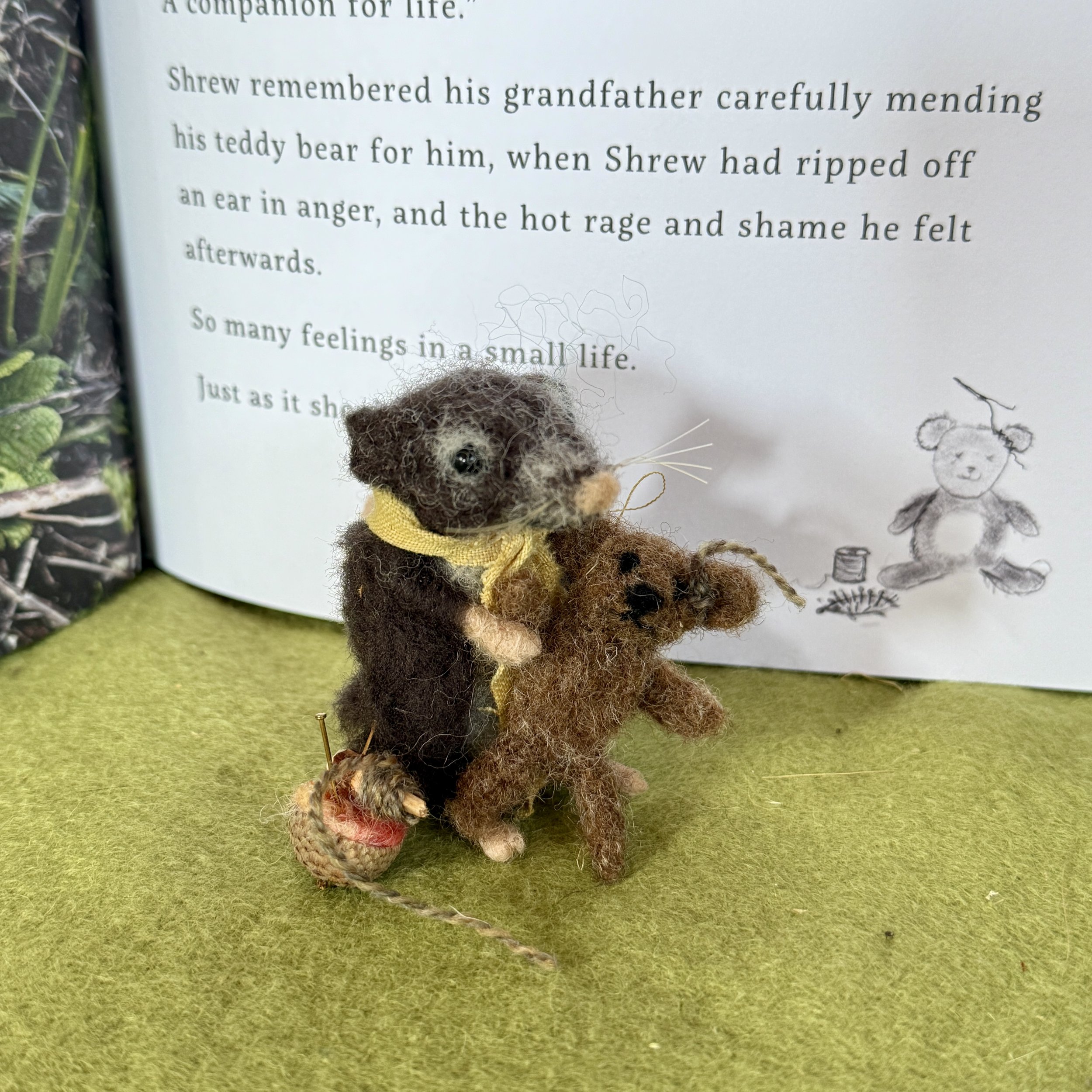 Grandfather Shrew mending the teddy bear. Needle felted shrew with a little teddy bear with a stitched ear. Acorn cup pin cushion.  approx 7cm tall