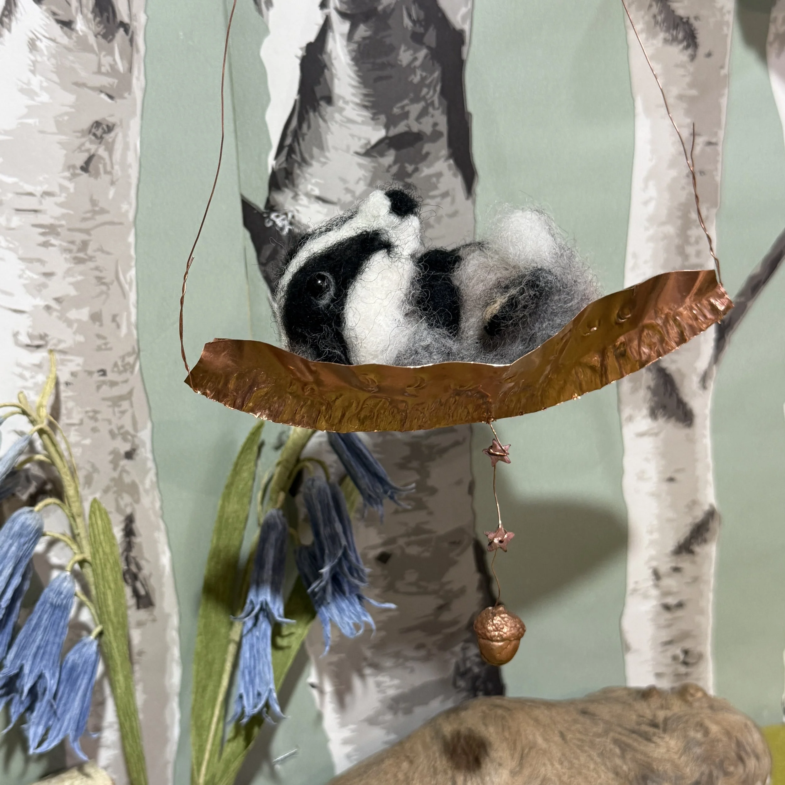 Baby Badger in a copper moon boat crib 
The crib is fold formed hand hammered pure copper foil, with tiny copper stars and a copper cast of an acorn. The boat is approx 14cm long badger is 8cm long £146