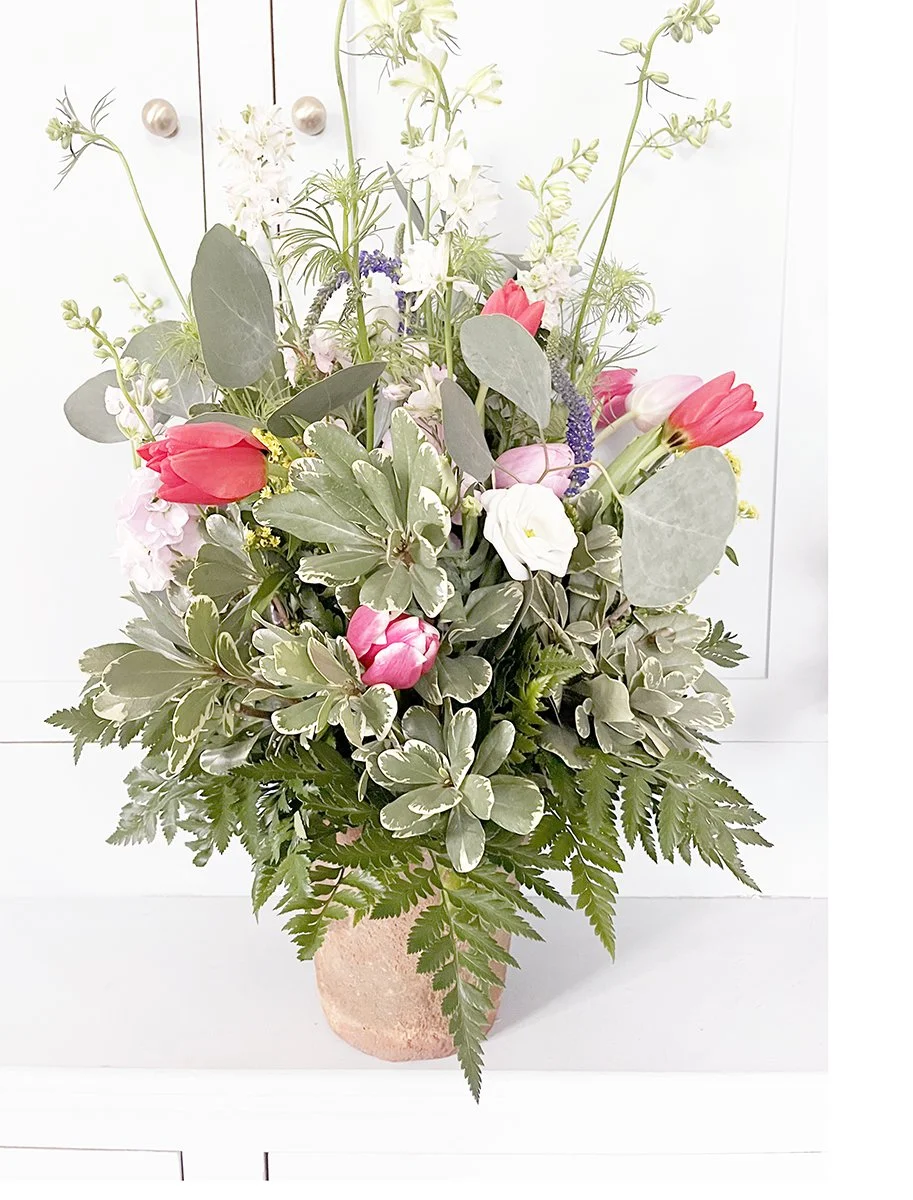 Medium-sized European garden–inspired floral arrangement with layered spring flowers in a French terracotta pot.