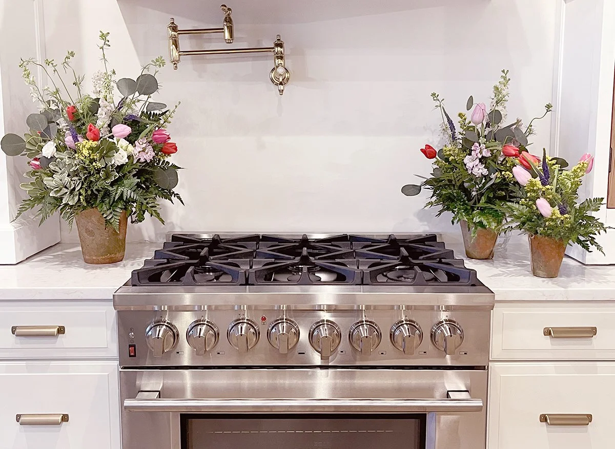 Parisian terracotta floral arrangements in three sizes shown side by side, highlighting scale and fullness differences.