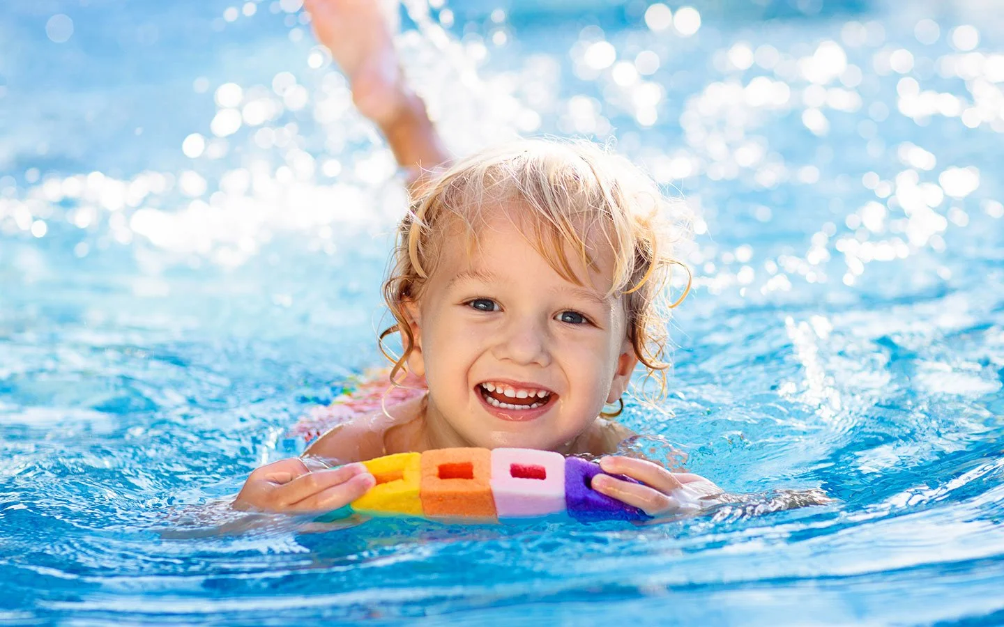 Young girl practicing swimming with a kickboard during a private swim lesson at Worden Aquatics in Nashville, TN.