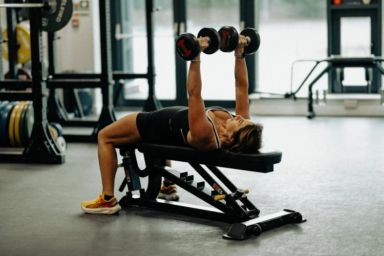 Athlete pressing dumbbells in the gym