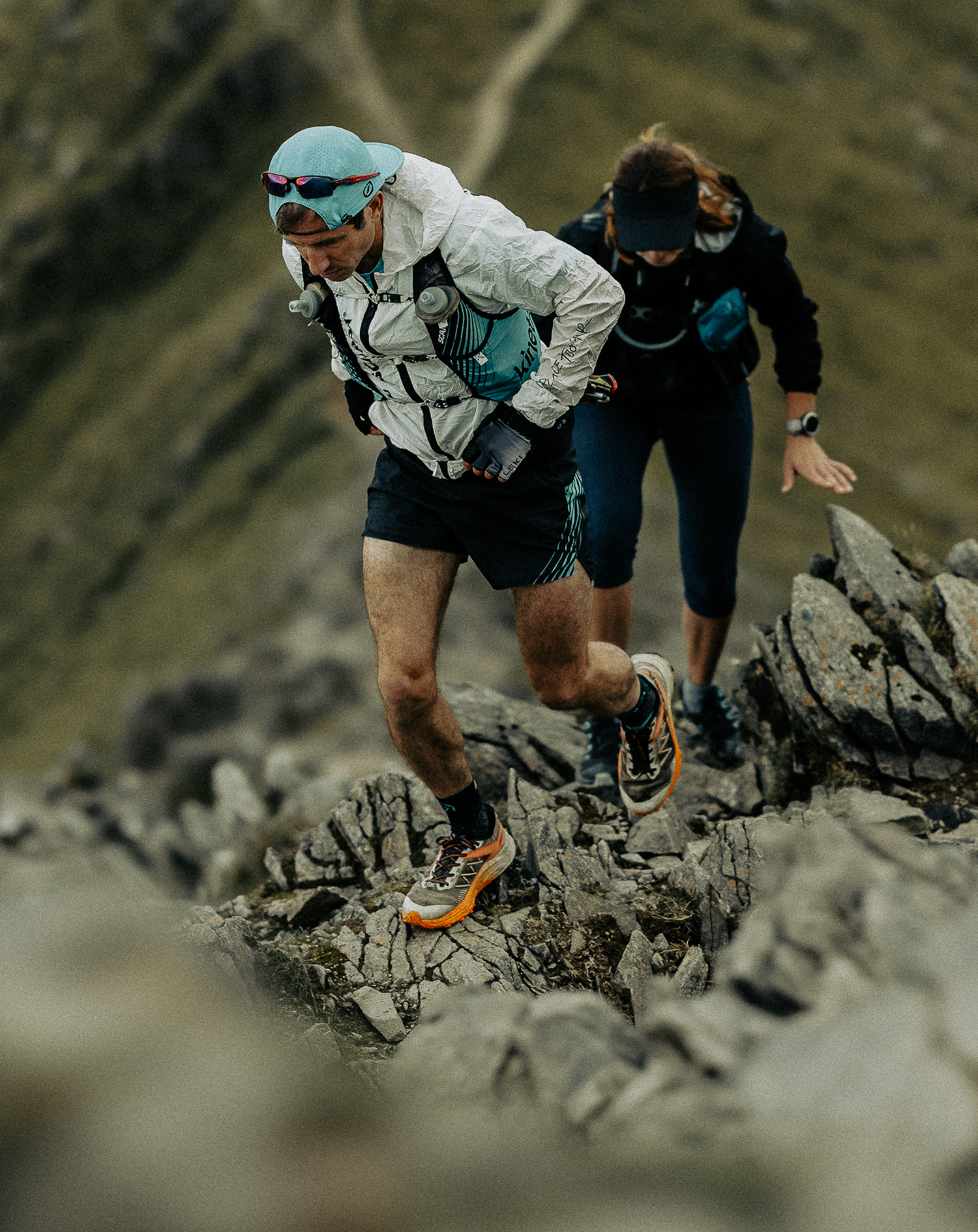 Two HP3 athletes running a rocky mountain ridge line