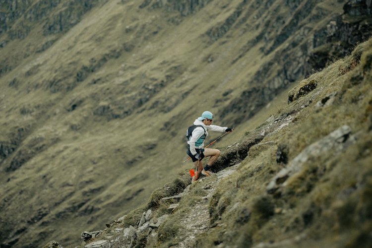 Tim running a green hillside trail