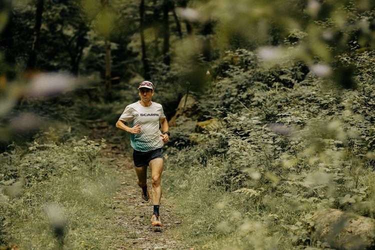 Tim trail running through a meadow