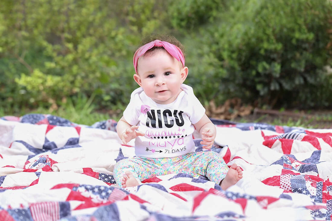 Baby Maya, a Heart Warrior Princess, sitting outdoors during her Austin Warrior Portrait photography session.