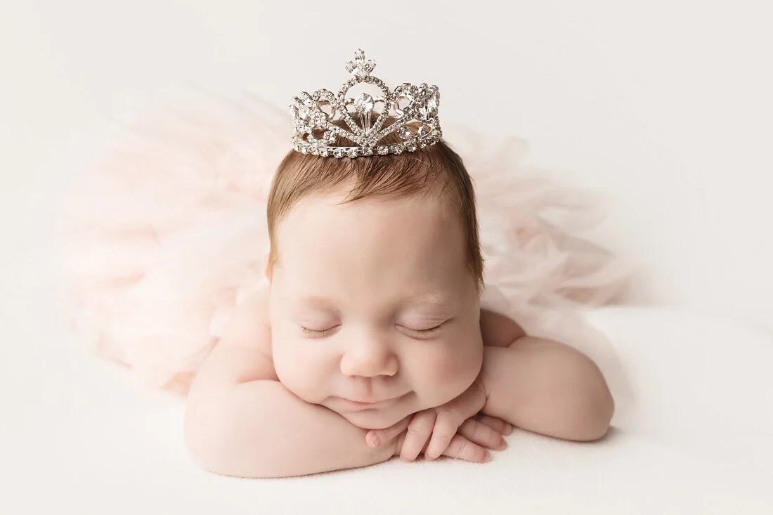 Baby Cassidy, a preemie warrior, sleeping while wearing a princess crown during her Austin newborn photography session.