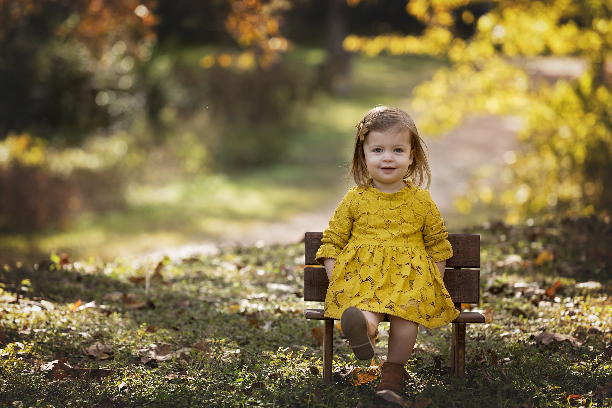 little girl on bench in autumn foliage
