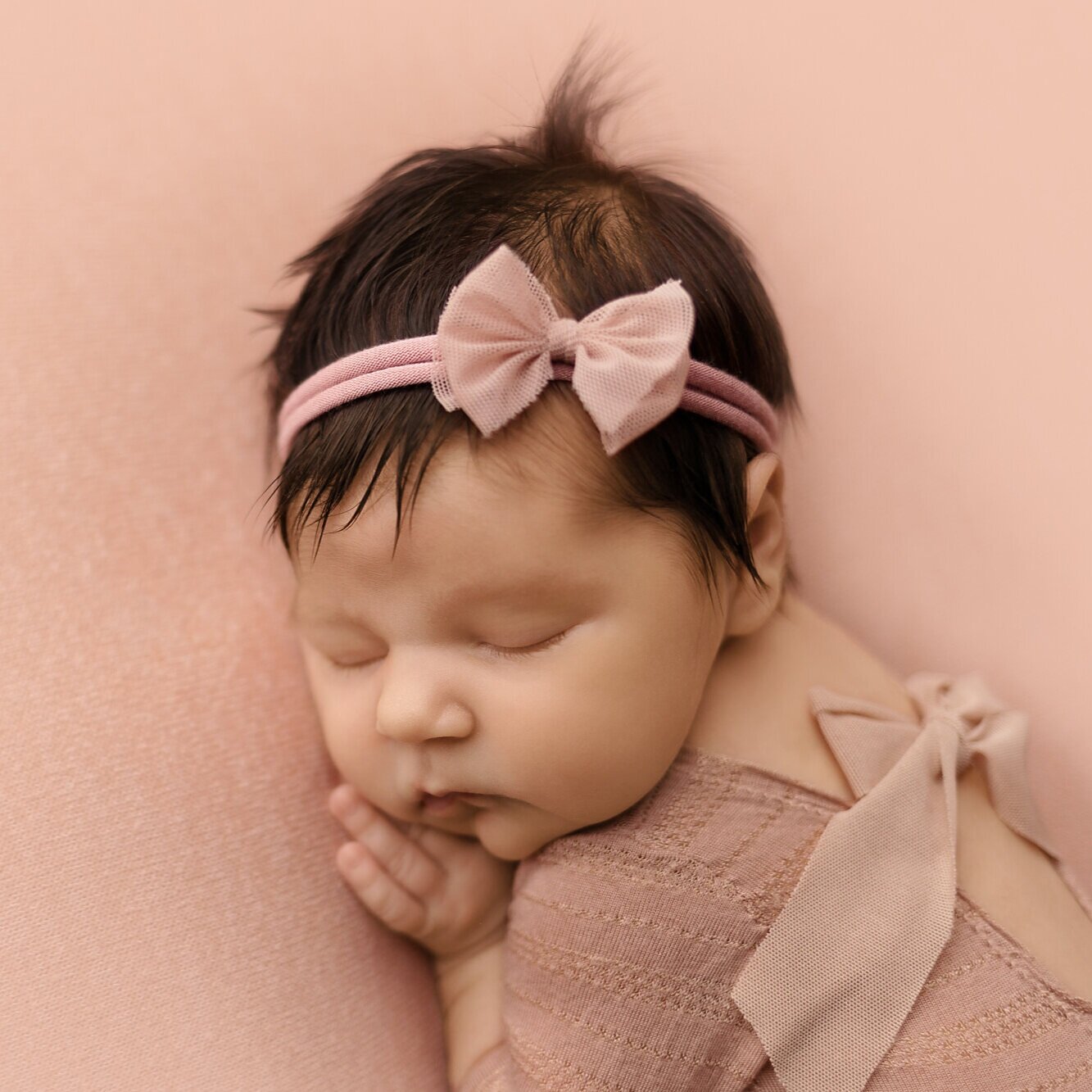 sleeping newborn girl with pink bow