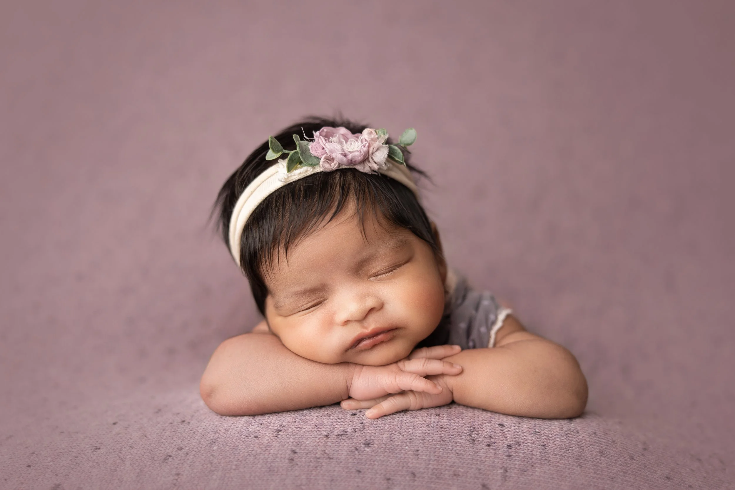 newborn-chin-on-hands-pose-purple-backdrop.jpg