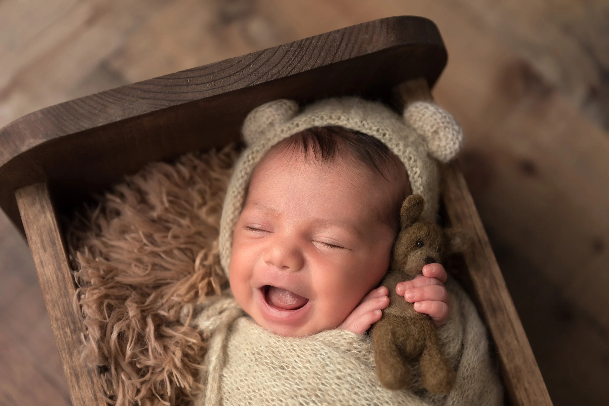 newborn-baby-smiling-wooden-prop-soft-neutral.jpg