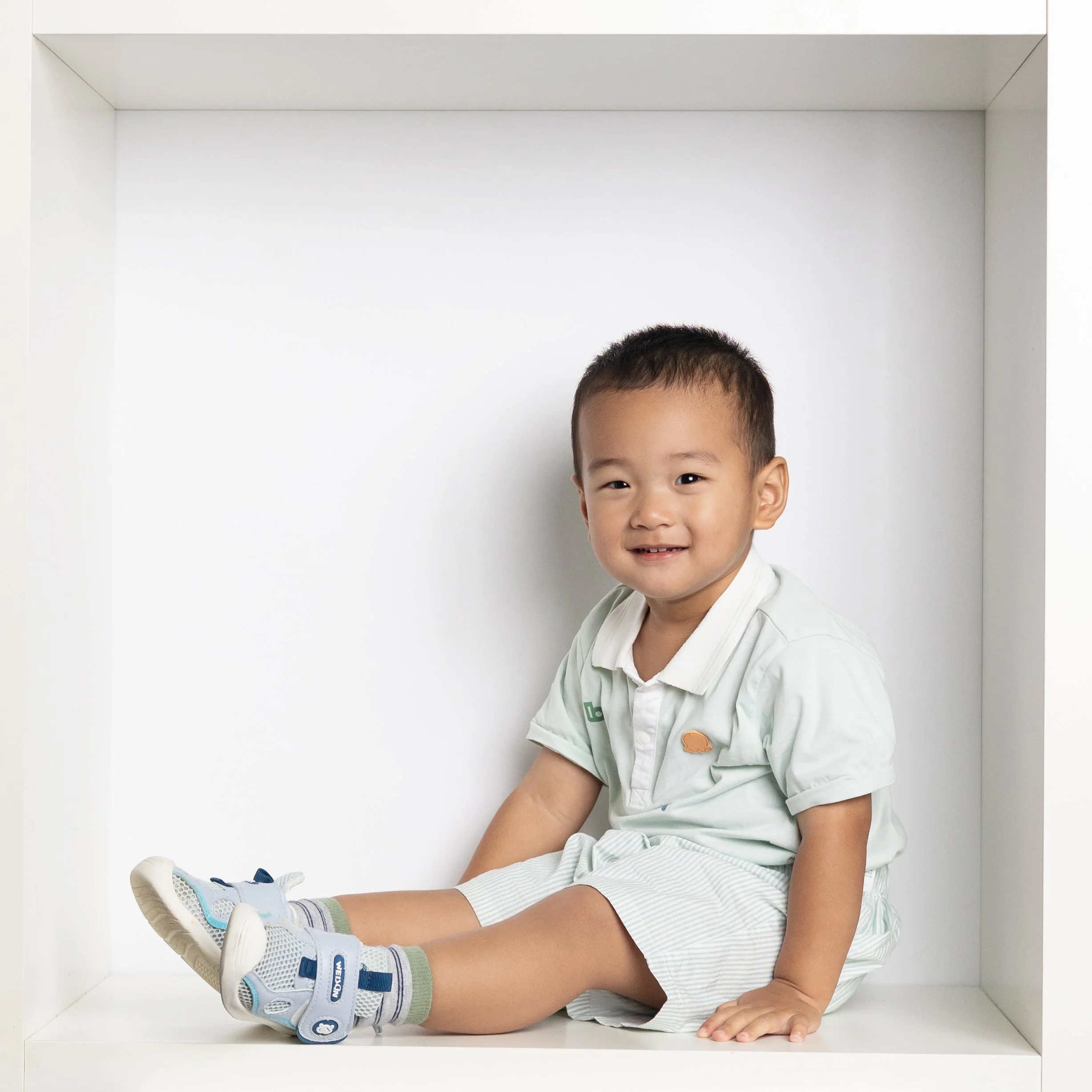  toddler boy sitting in box for photography session 