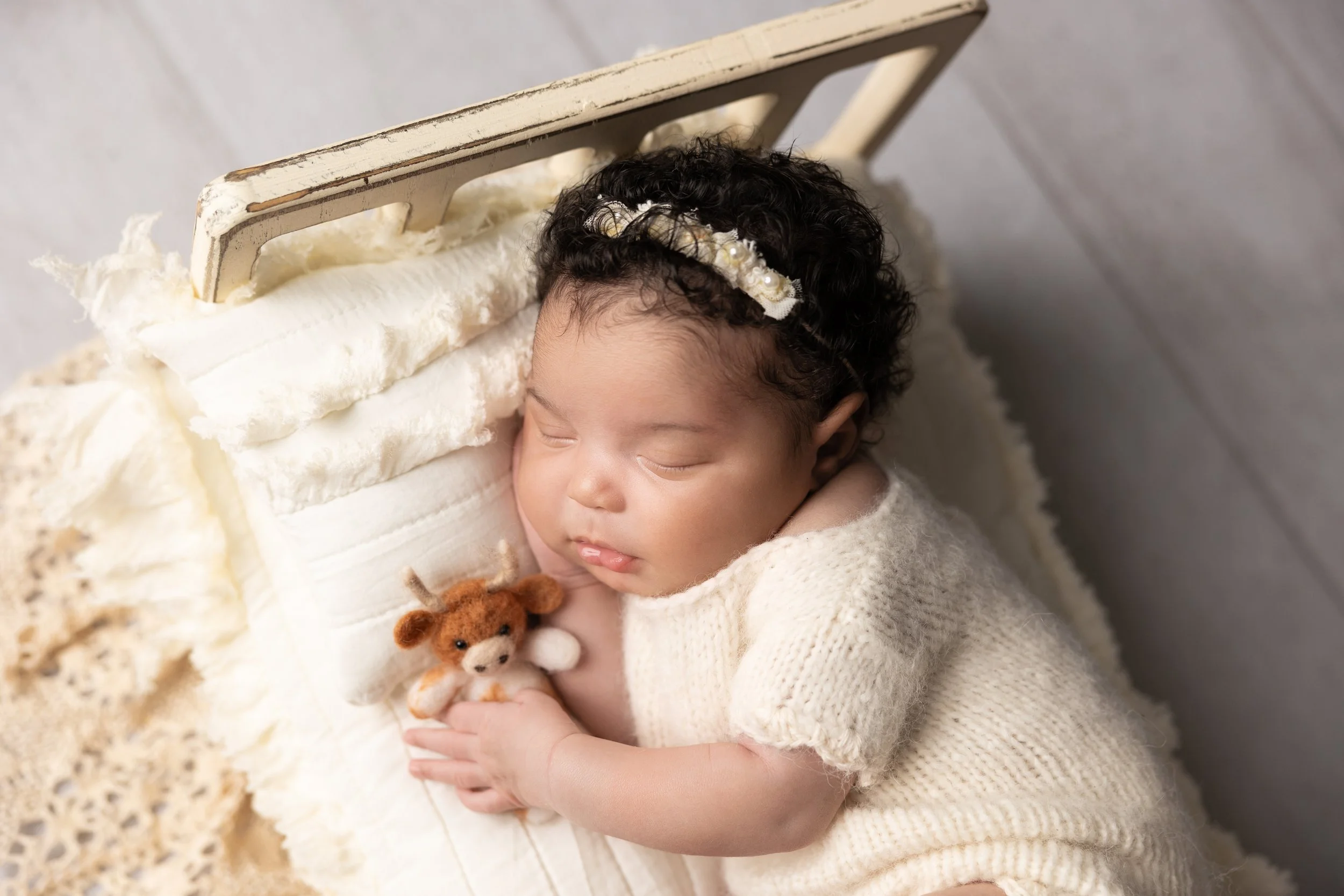 newborn-girl-sleeping-holding-longhorn-lovie