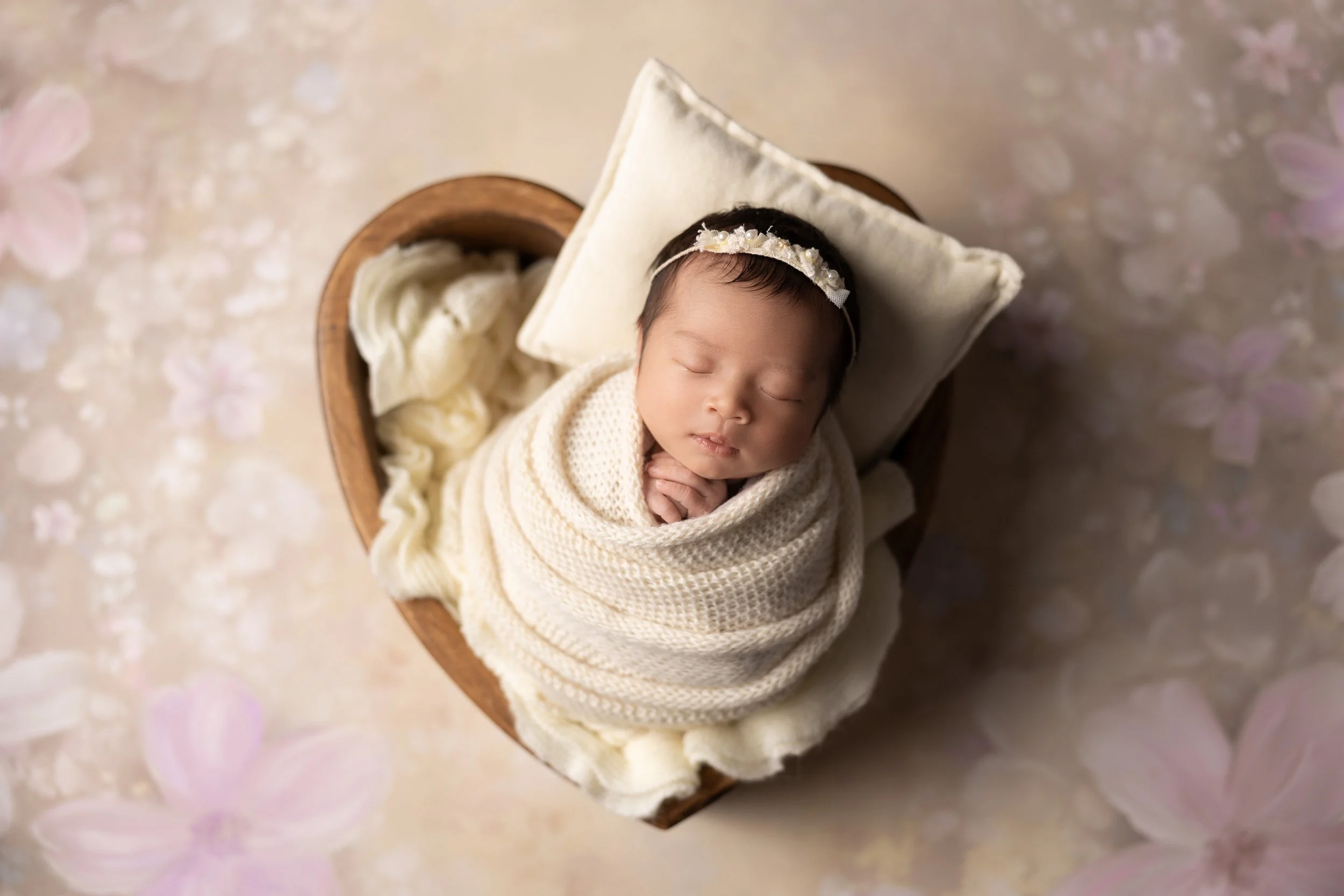 newborn in beige prop setup