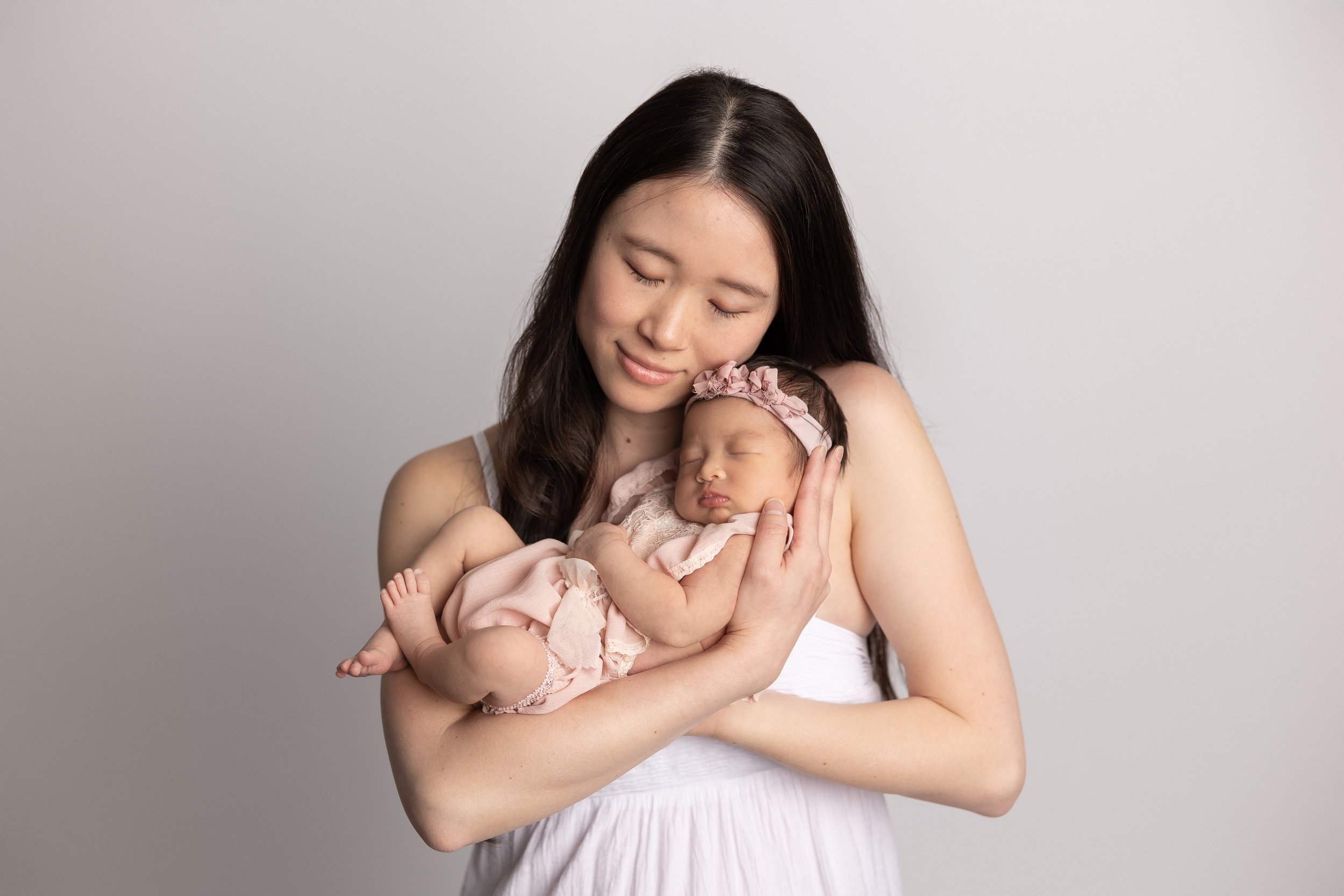 mom holding newborn neutral tones
