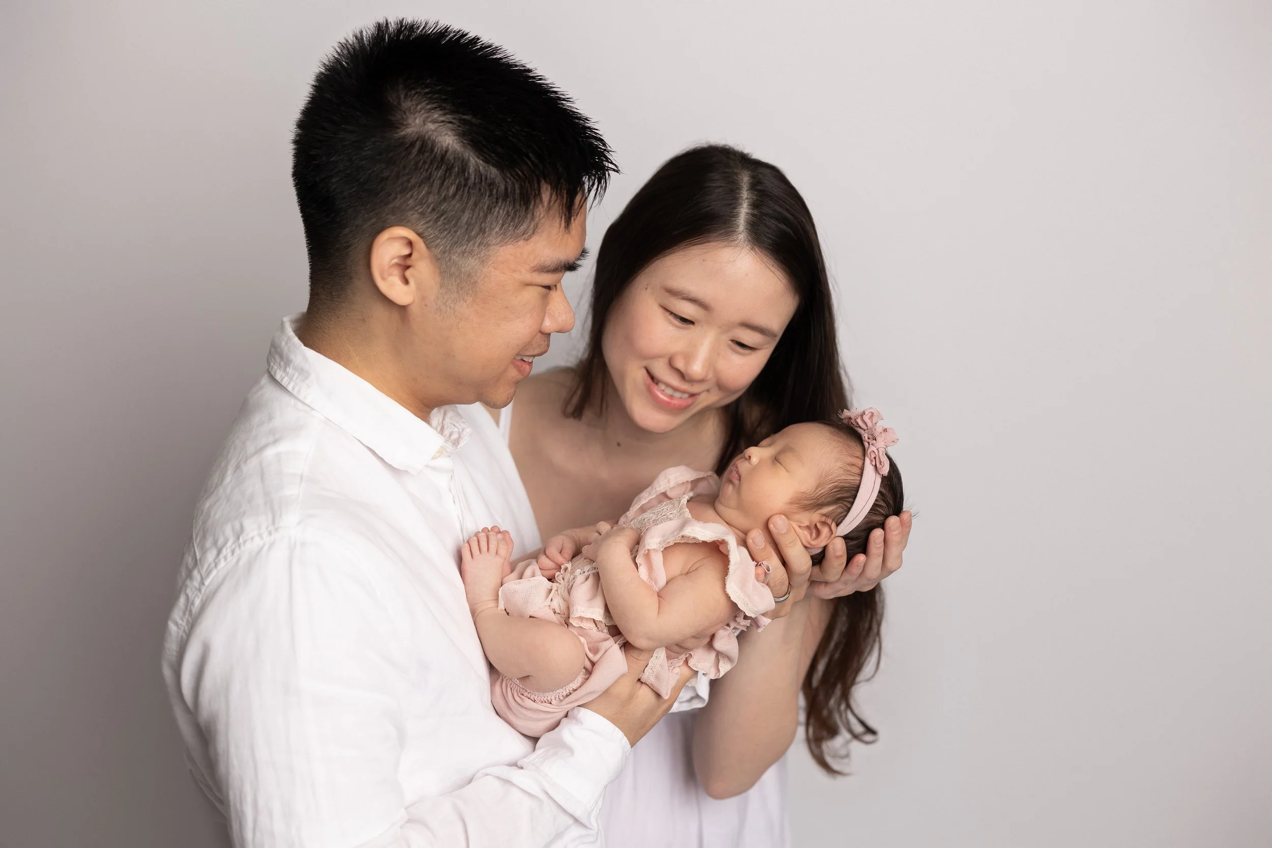 parents holding newborn together