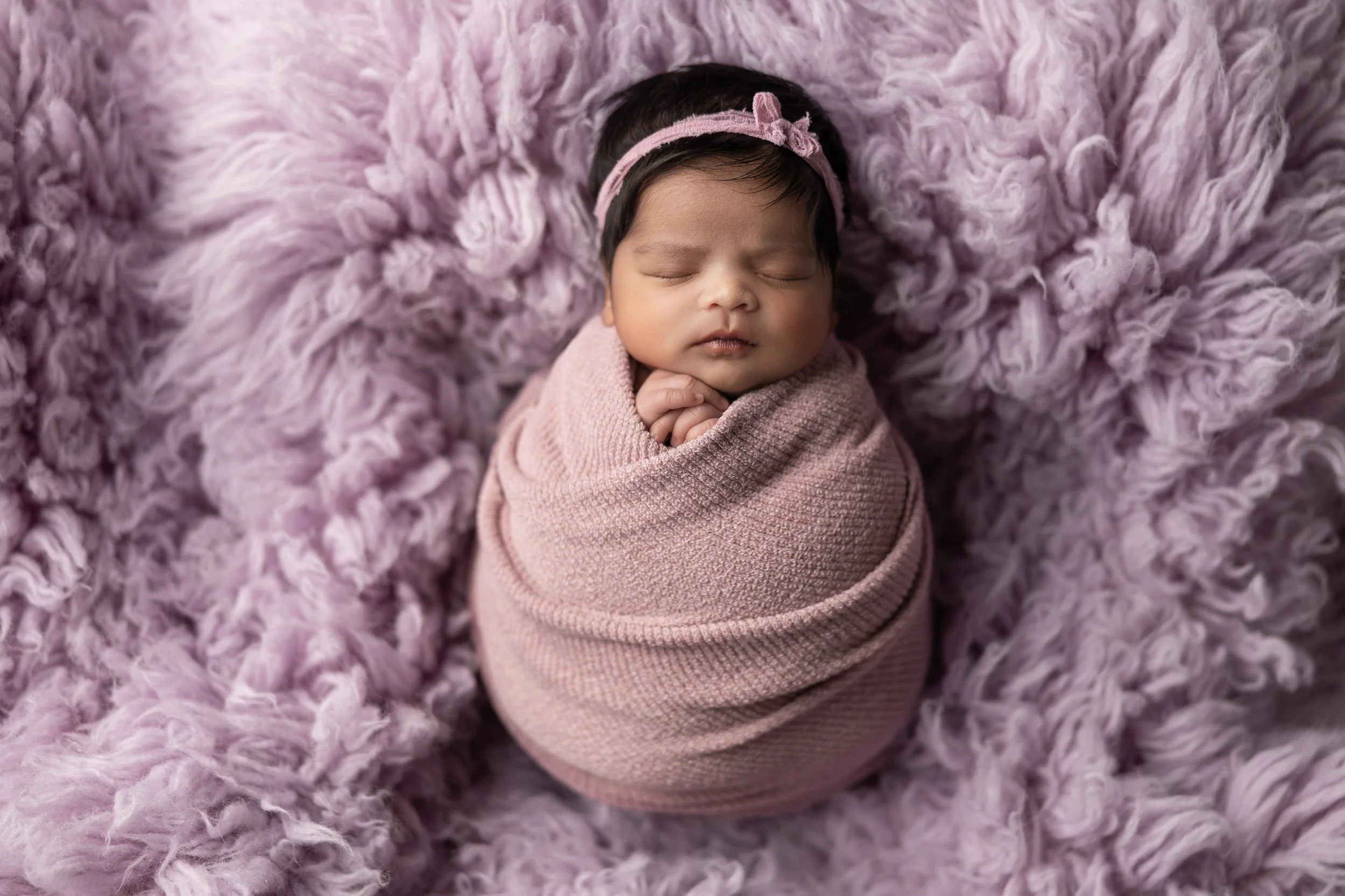 newborn in purple setup with organic textures