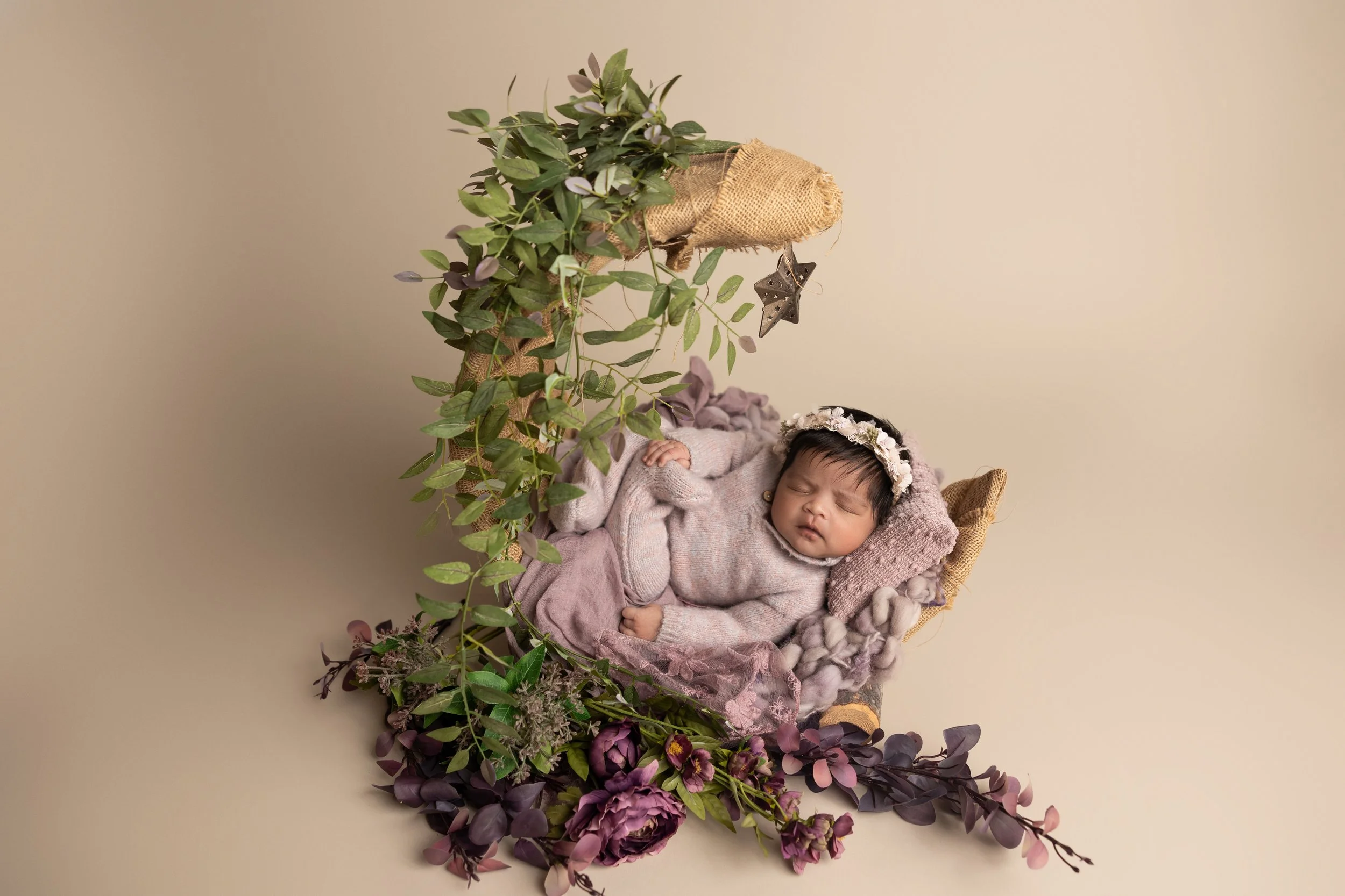 newborn posed in rustic moon prop with neutral styling