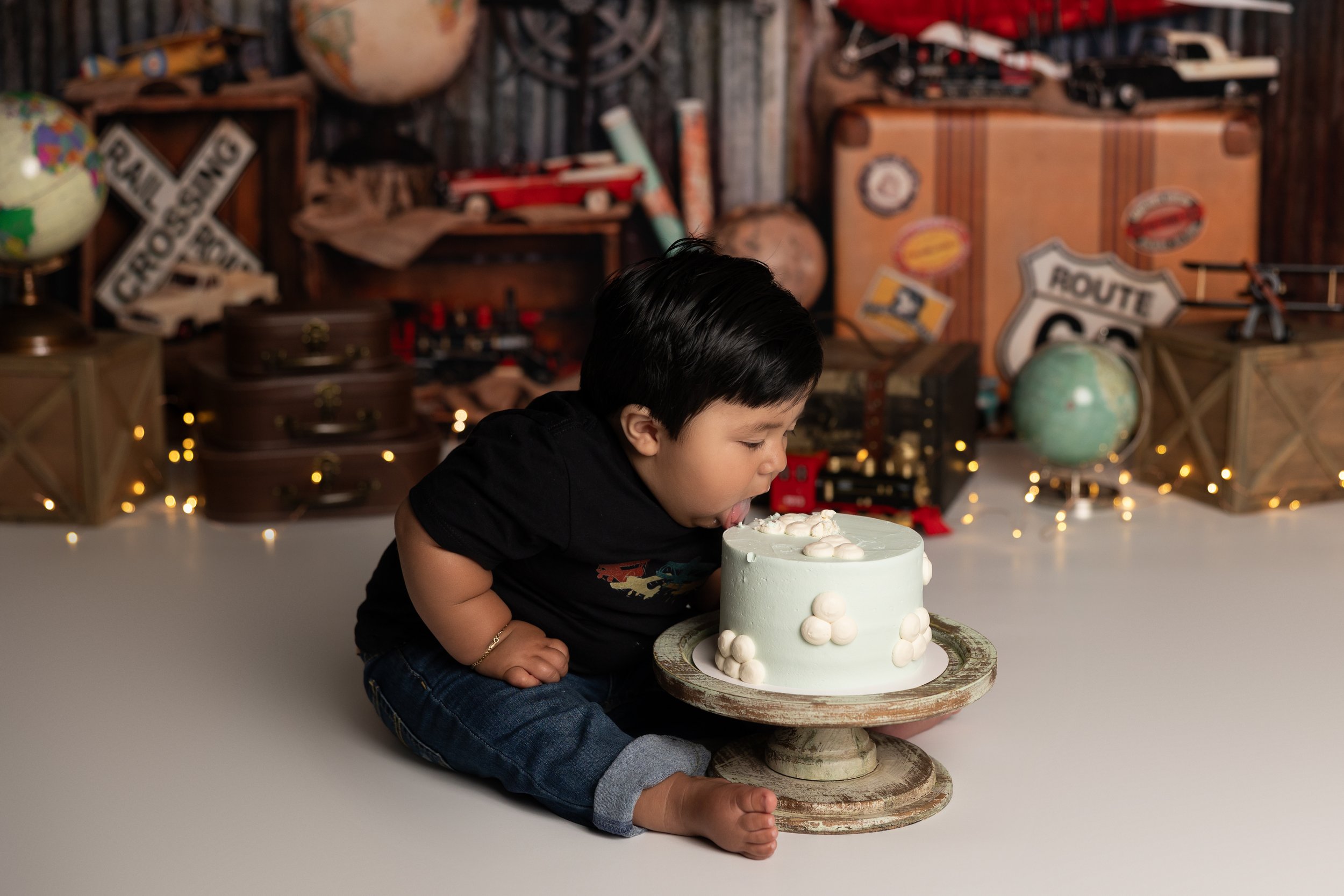 Travel cake smash – first birthday boy with cake during smash session