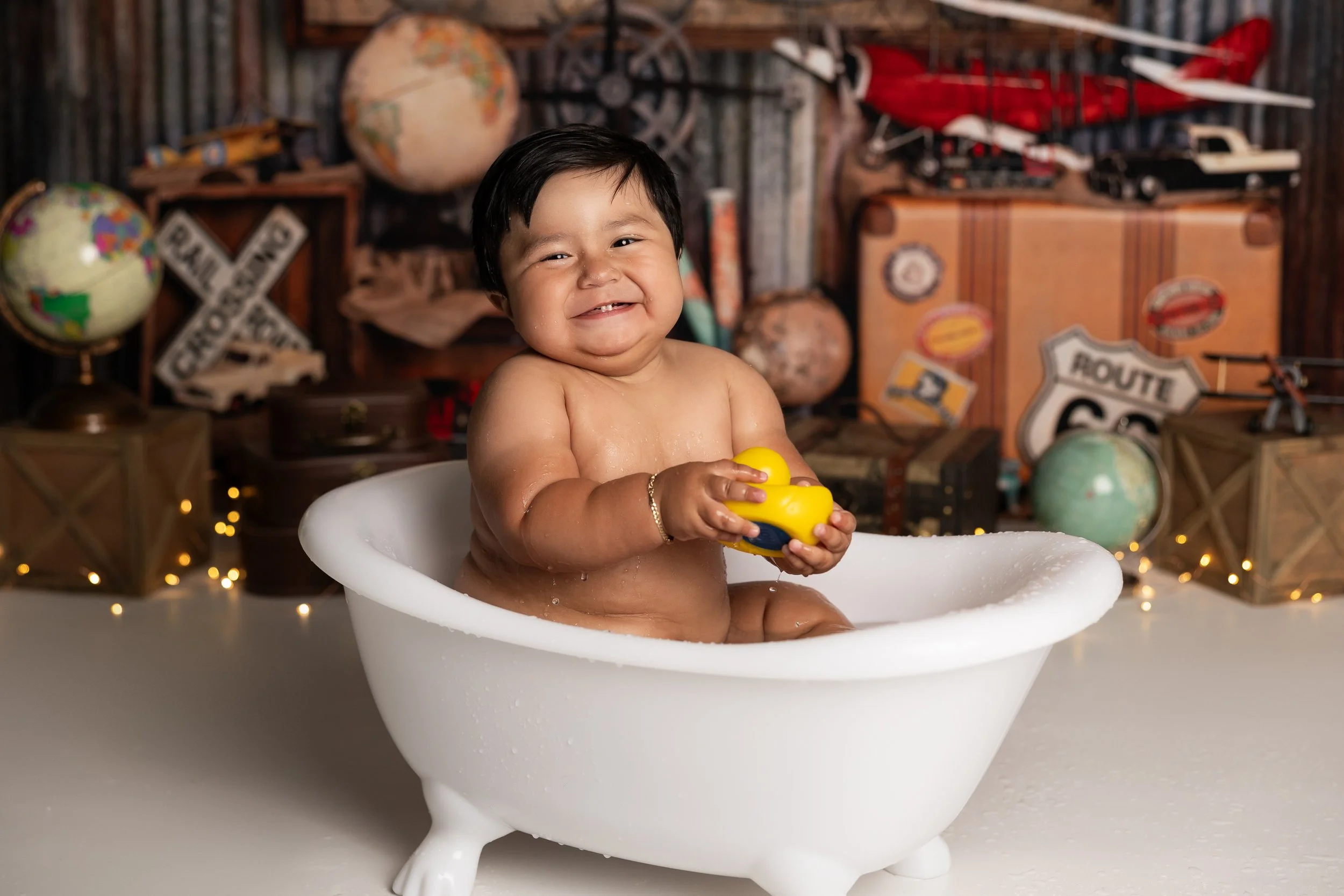 Cake smash bath photo – first birthday boy travel theme cleanup